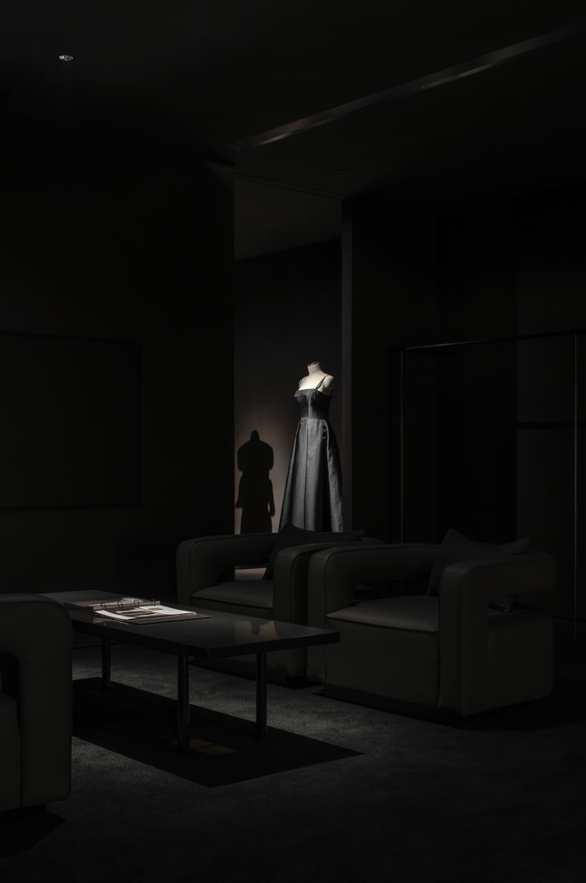 A minimalist living room featuring a modern black sofa, chairs, and a sleek coffee table.
