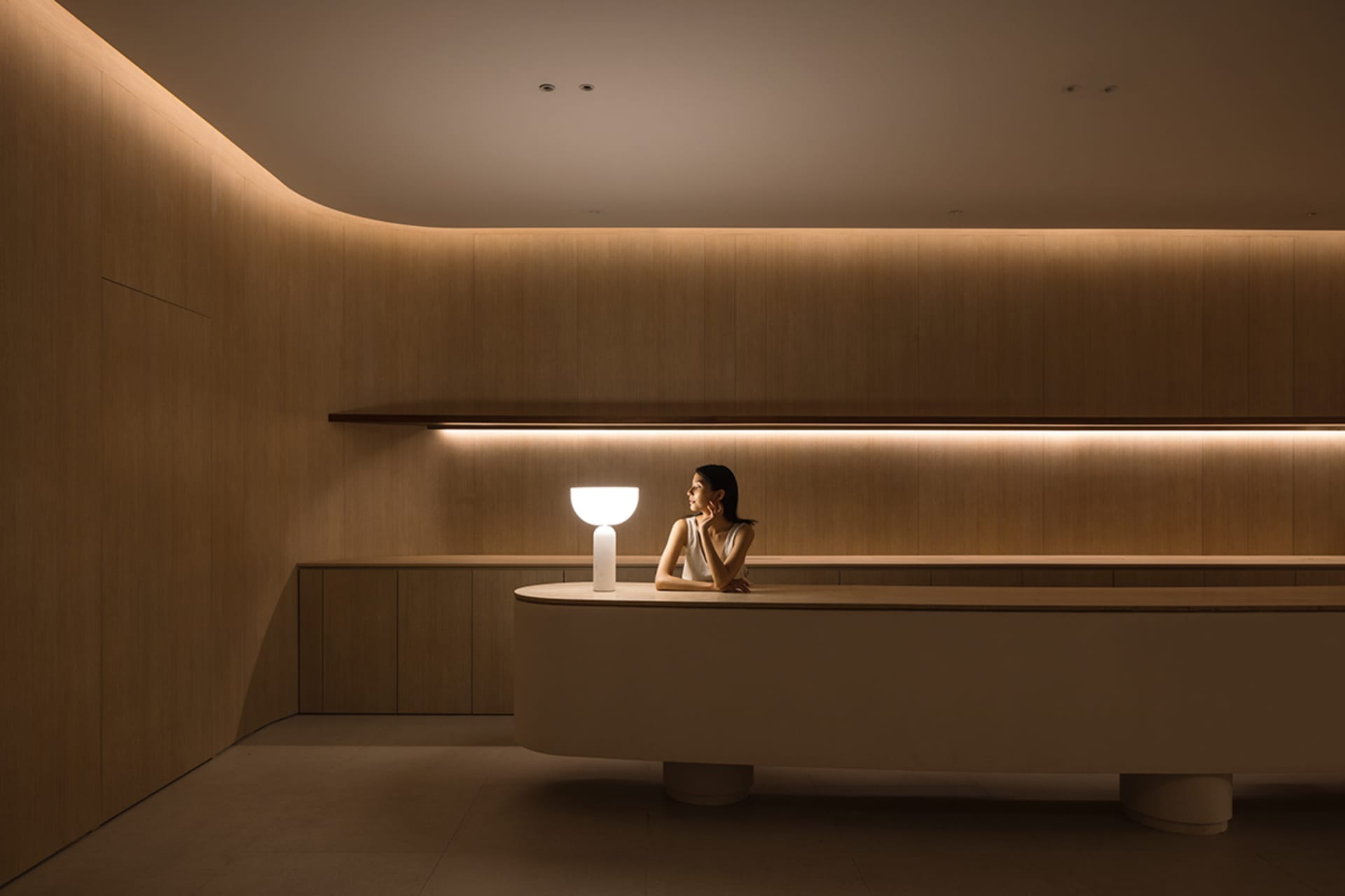 A modern minimalist lounge with wooden walls and glass elements.