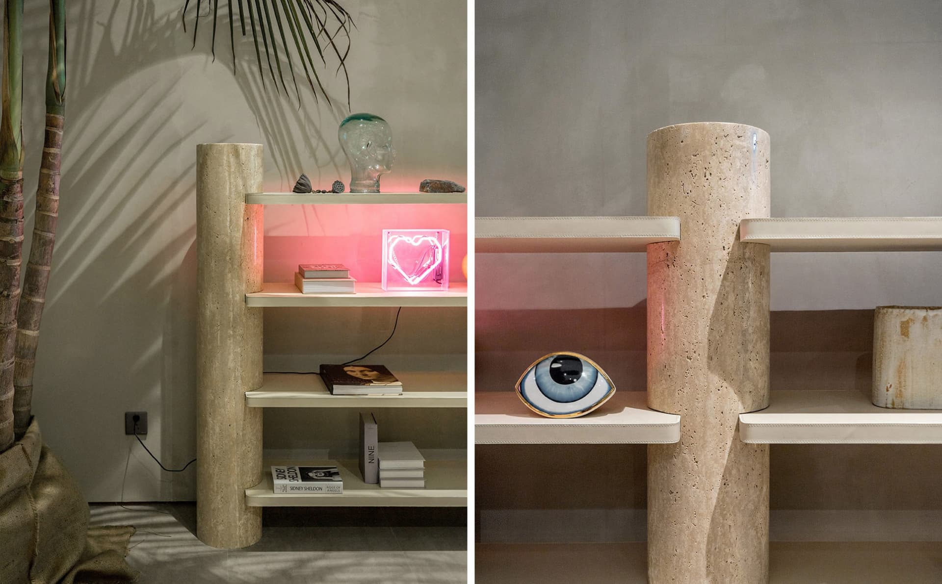 A modern limestone bookshelf with a pink heart-shaped neon light and a decorative eye-shaped object.