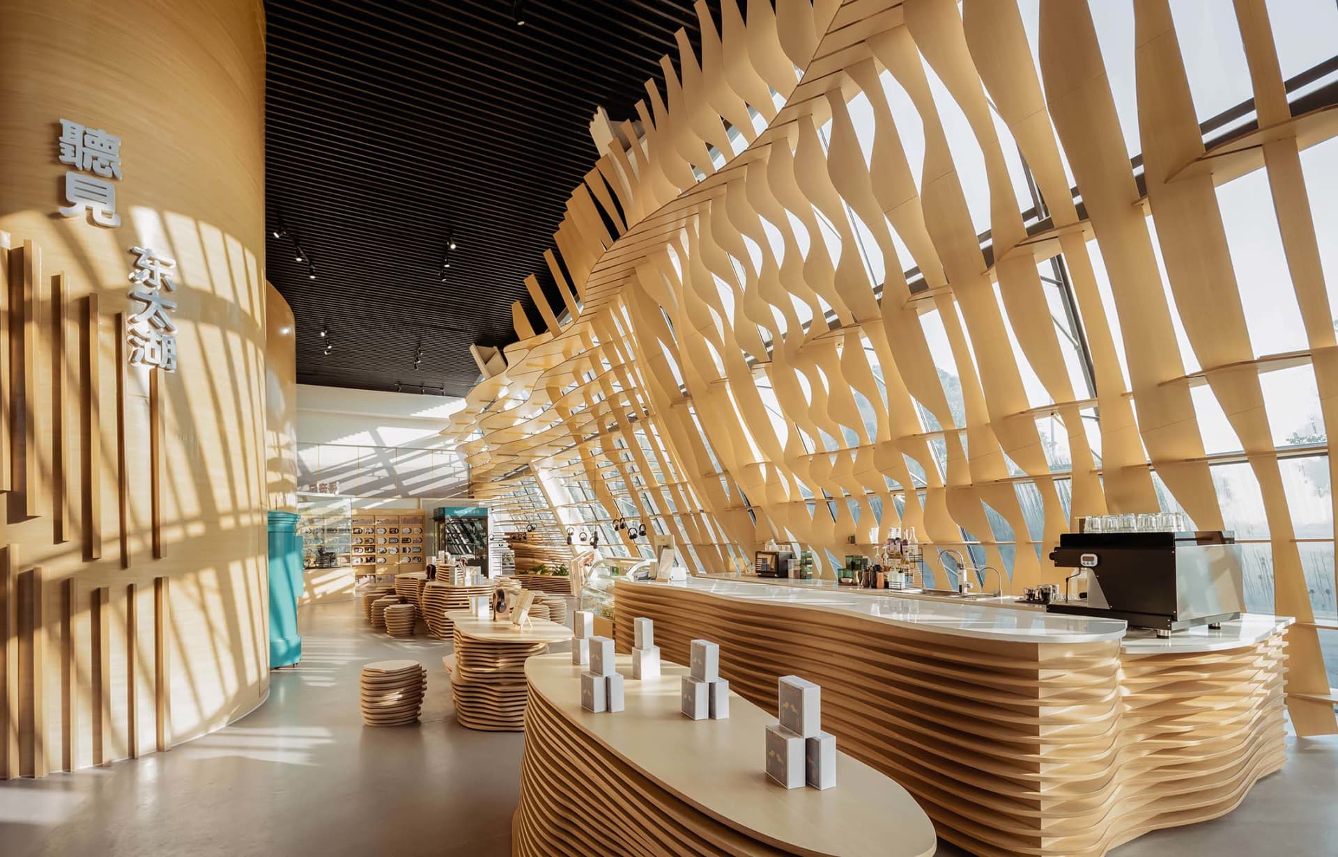 A modern minimalist restaurant interior featuring a wave-like wooden facade and organic shapes.