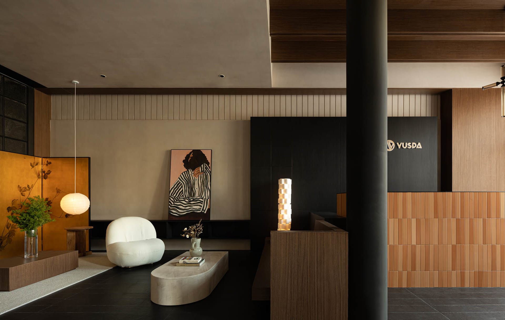 A modern lobby area featuring a wooden paneling wall with a seating area and a reception desk. The design includes minimalist