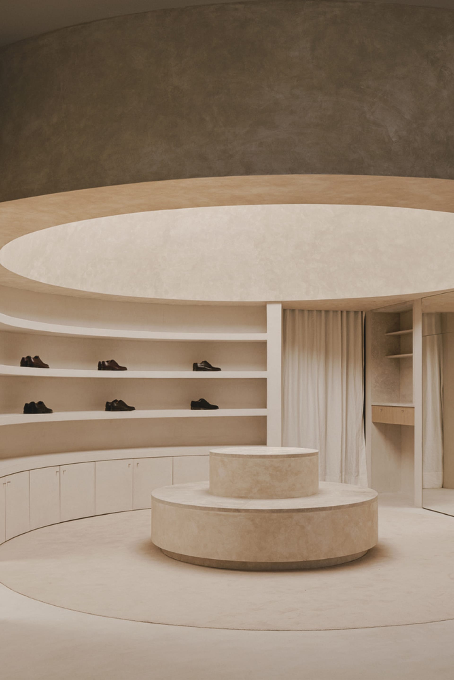 A minimalist shoe closet featuring concrete and wood materials.