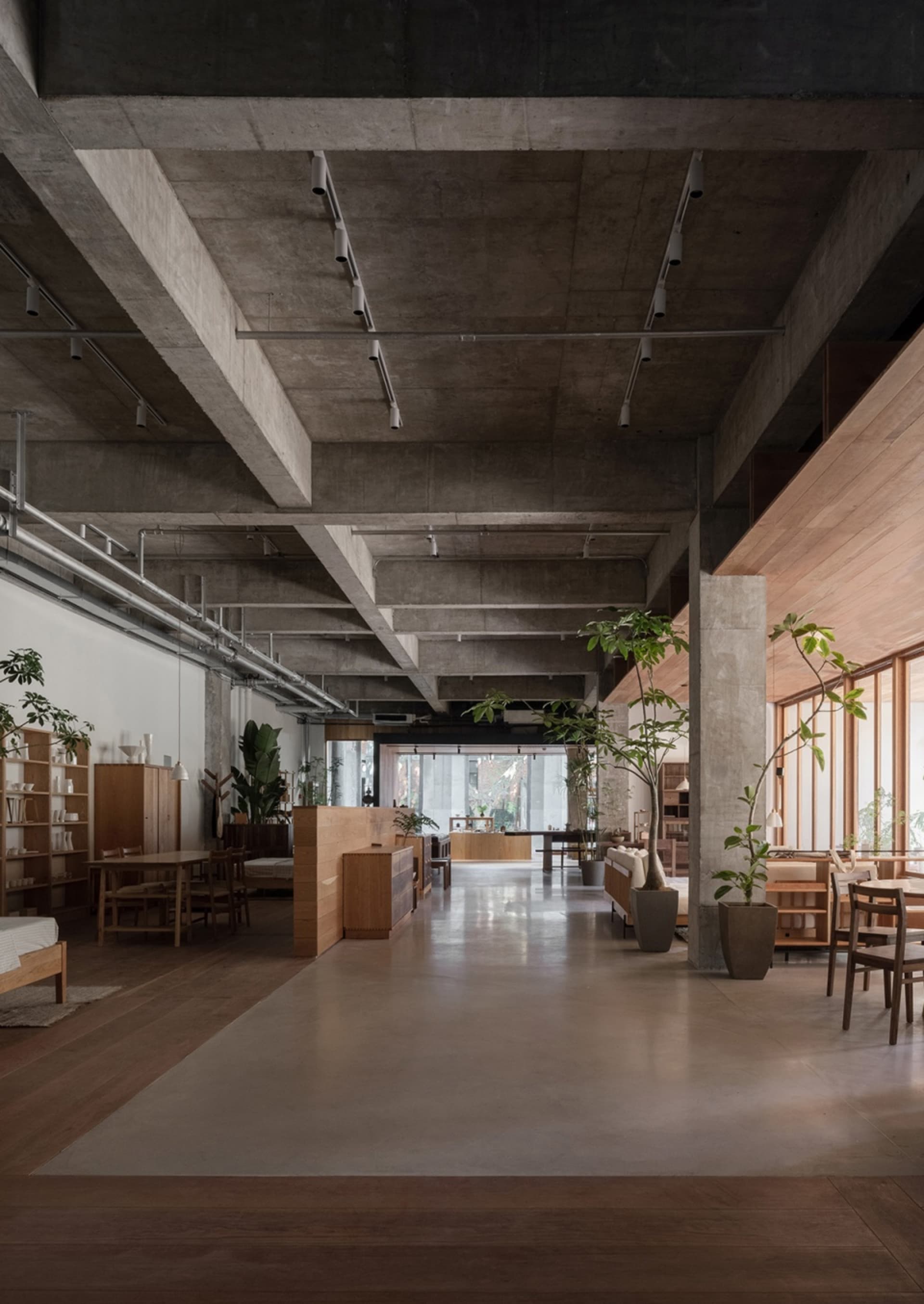 A modern industrial office space featuring concrete and wood materials.