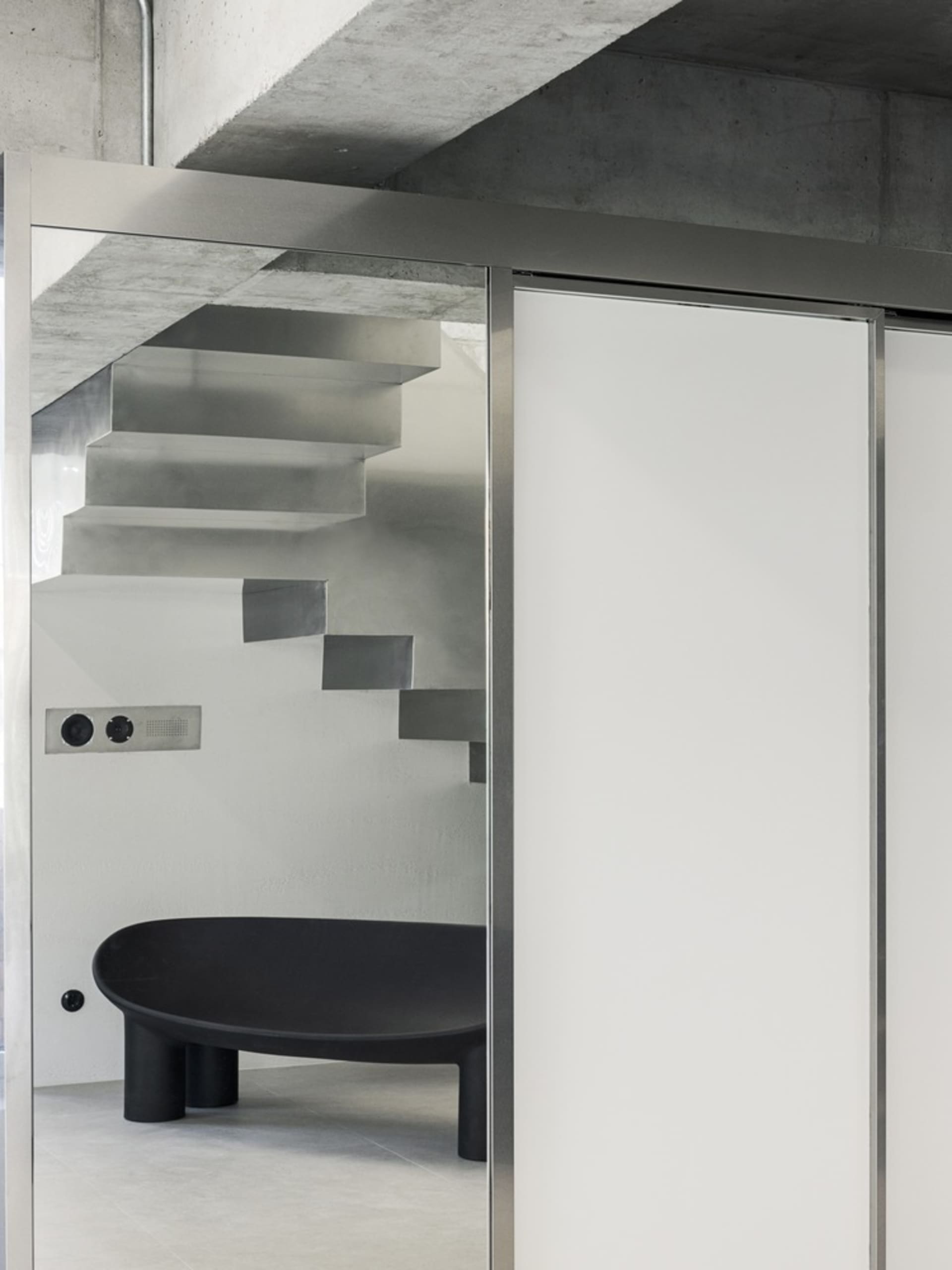 Modern interior with concrete stairs and steel furniture