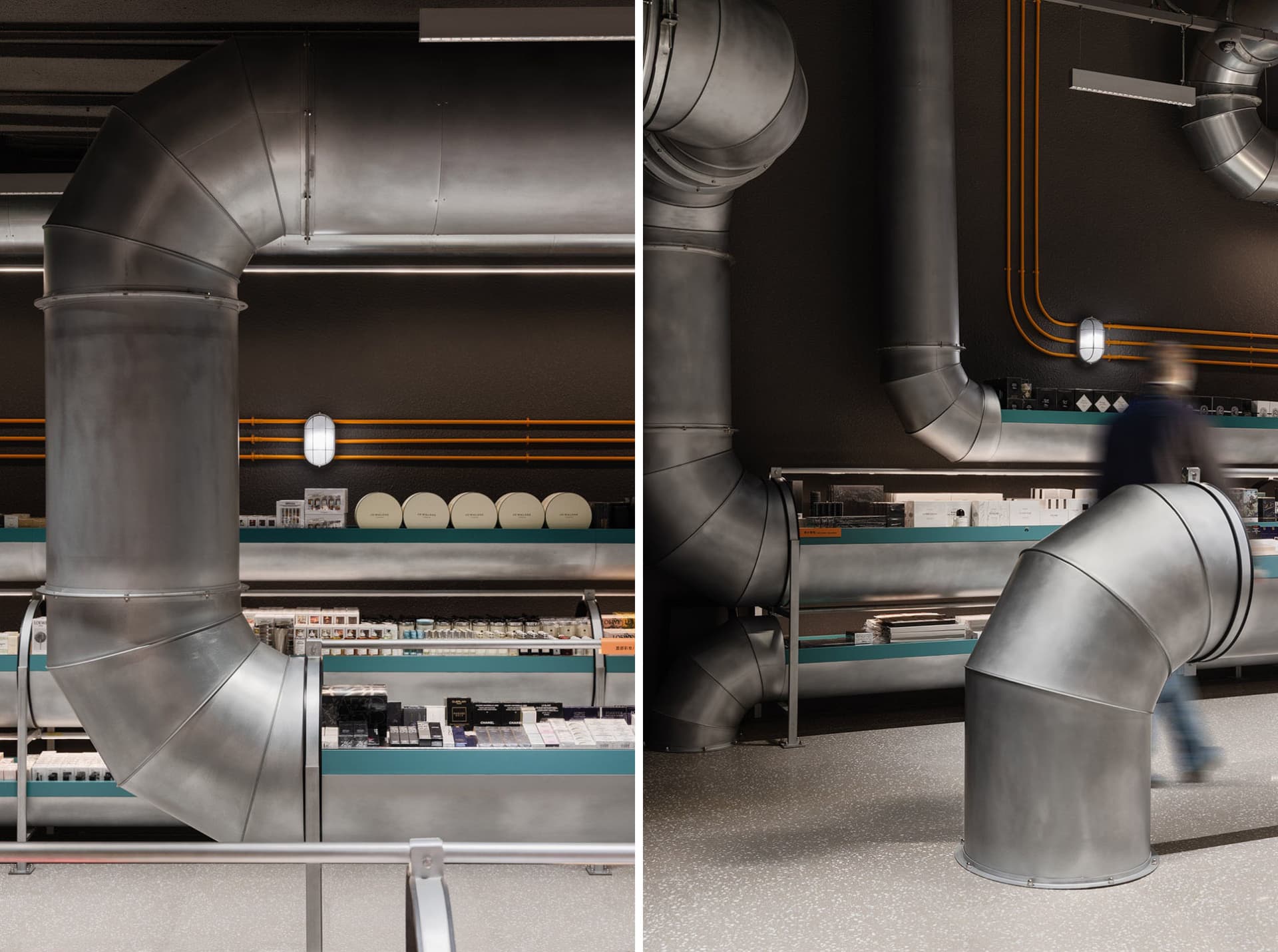 A retail storefront featuring large, metallic pipes against a dark, textured wall, creating an industrial aesthetic.