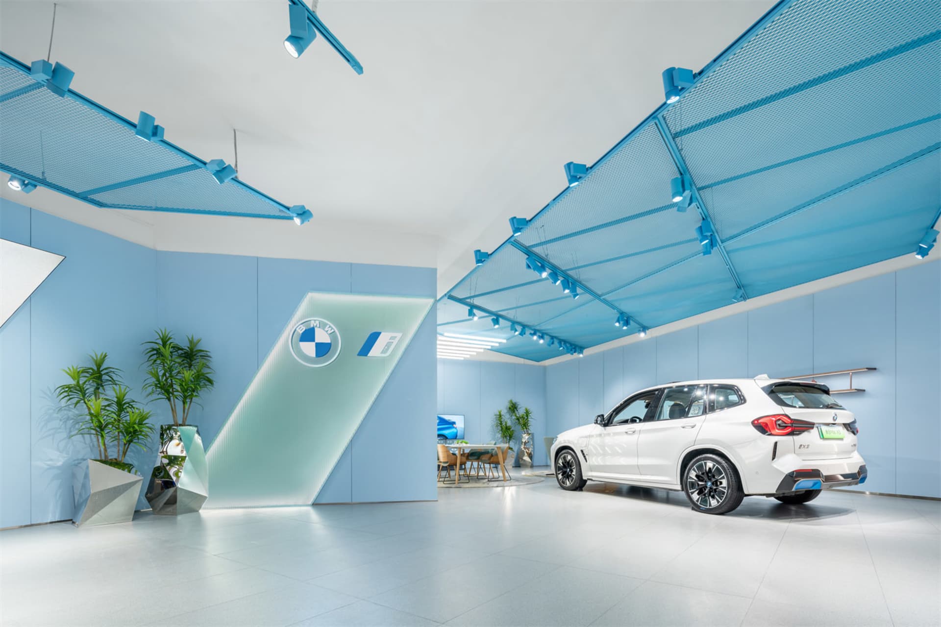 Modern, minimalist showroom featuring a BMW iX3 electric SUV.
