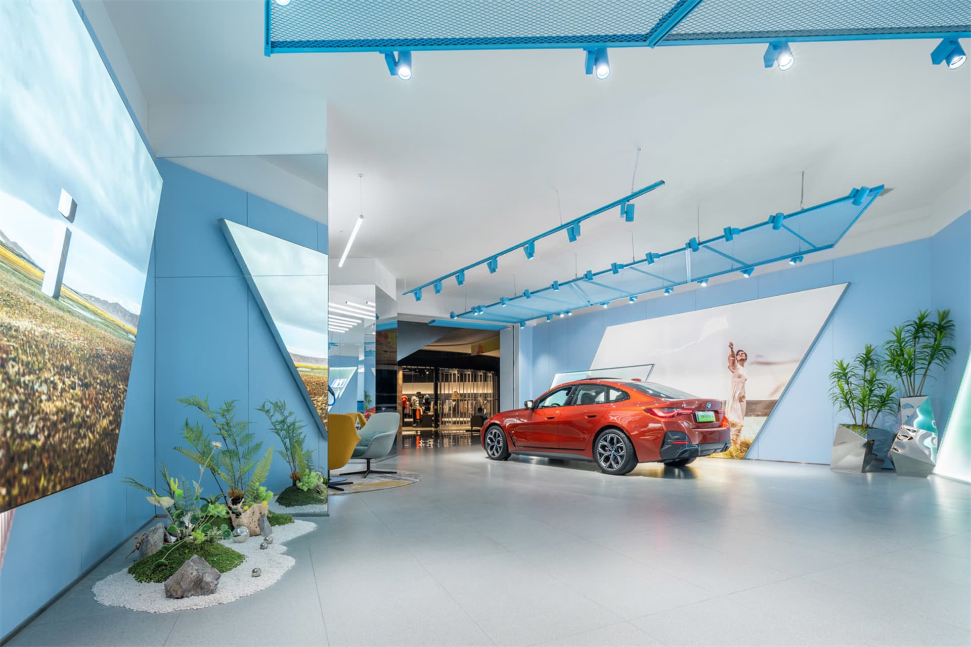 現代汽車展覽展示區，藍色牆面、玻璃牆與橘色汽車。