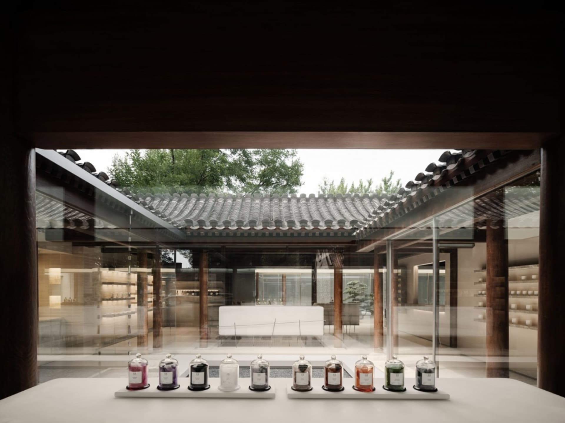 A traditional tea room with concrete and glass windows, featuring a row of small jars in front of the entrance.