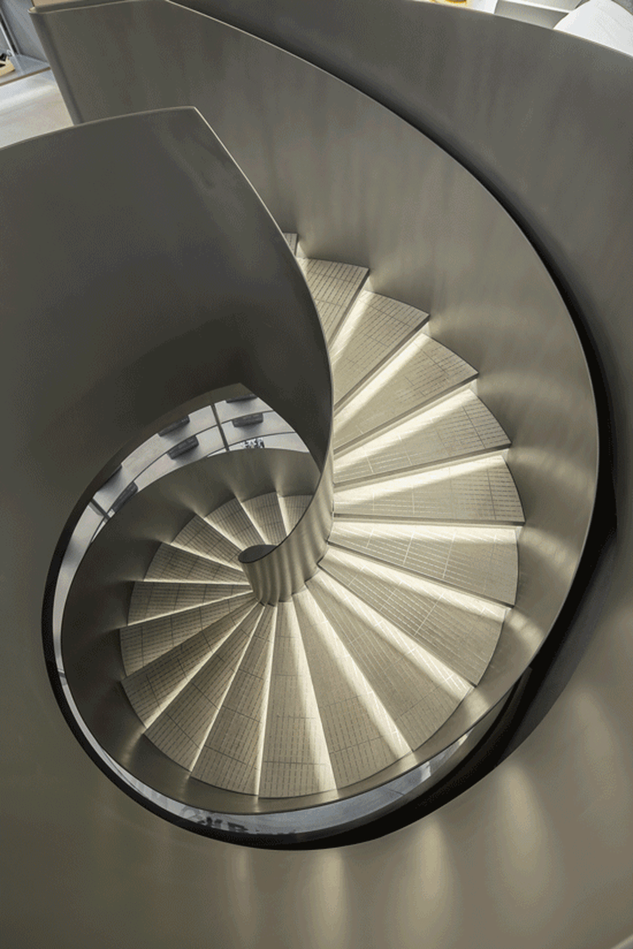 Spiral staircase constructed from metallic material, providing a modern and industrial aesthetic.