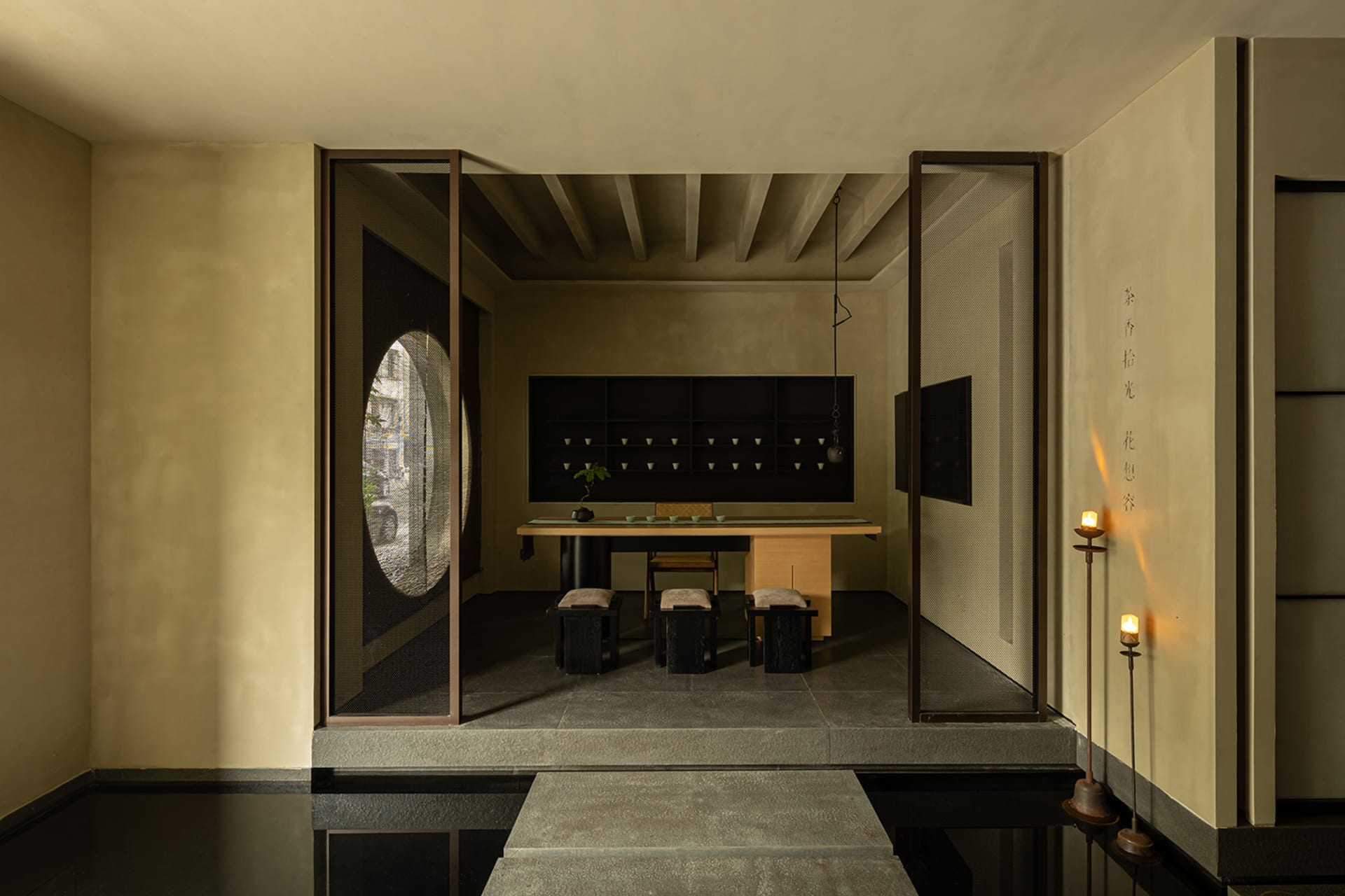 A minimalist tea room featuring a wooden table and seating area, with traditional Japanese elements.