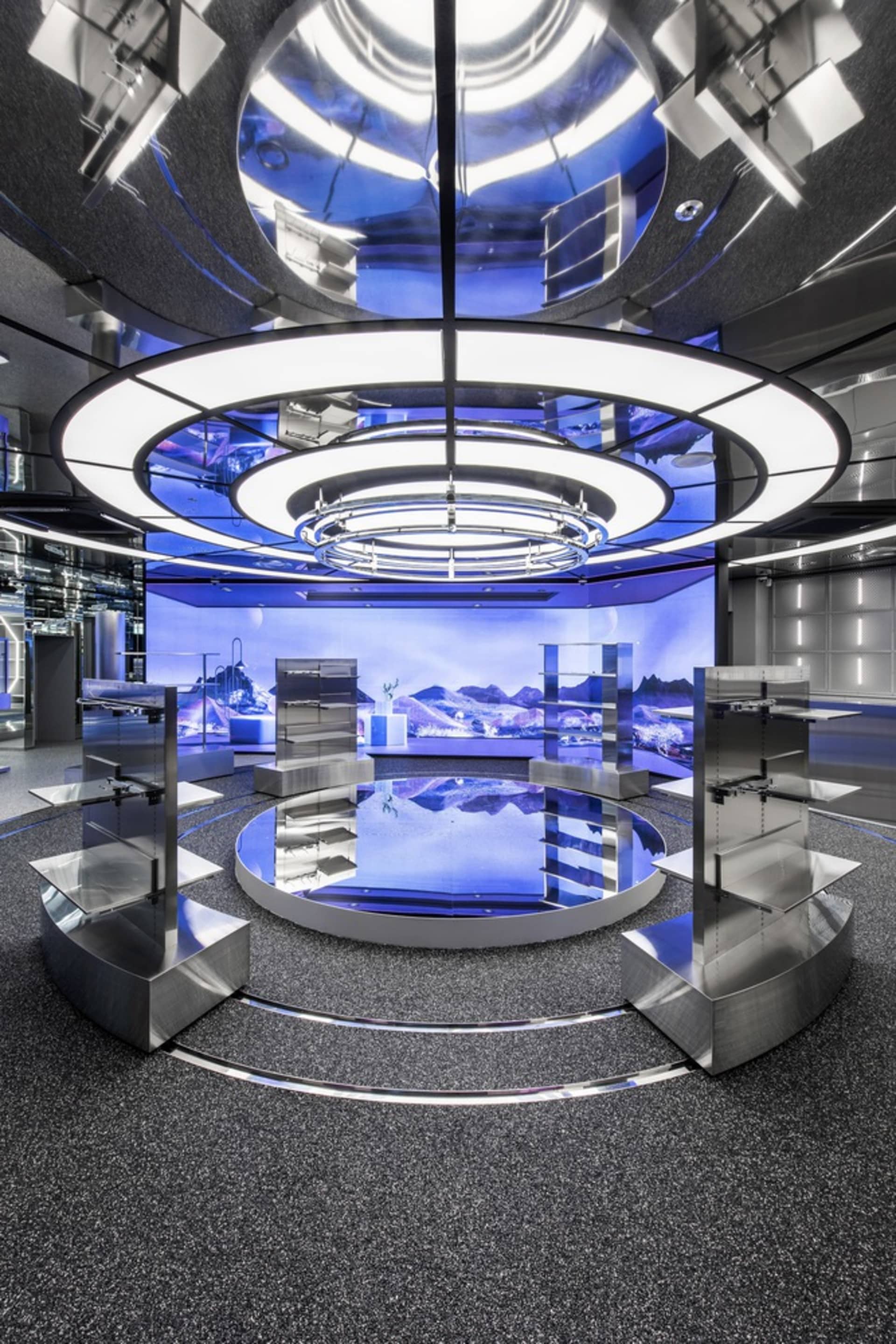 A futuristic, metallic, technology-themed showroom with circular lights and digital displays.