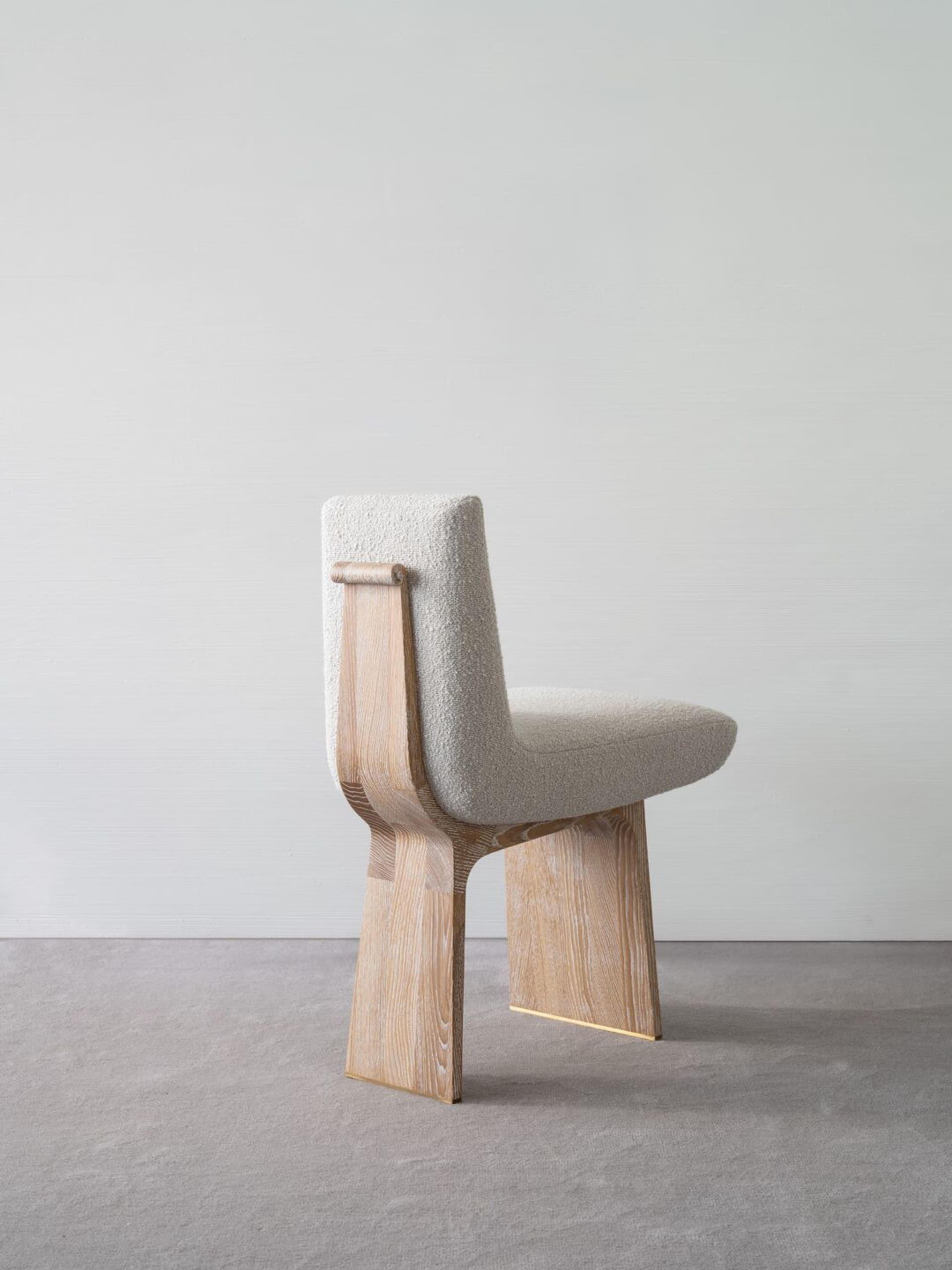 Modern contemporary dining chair made of wood with a tweed seat and brass accents.