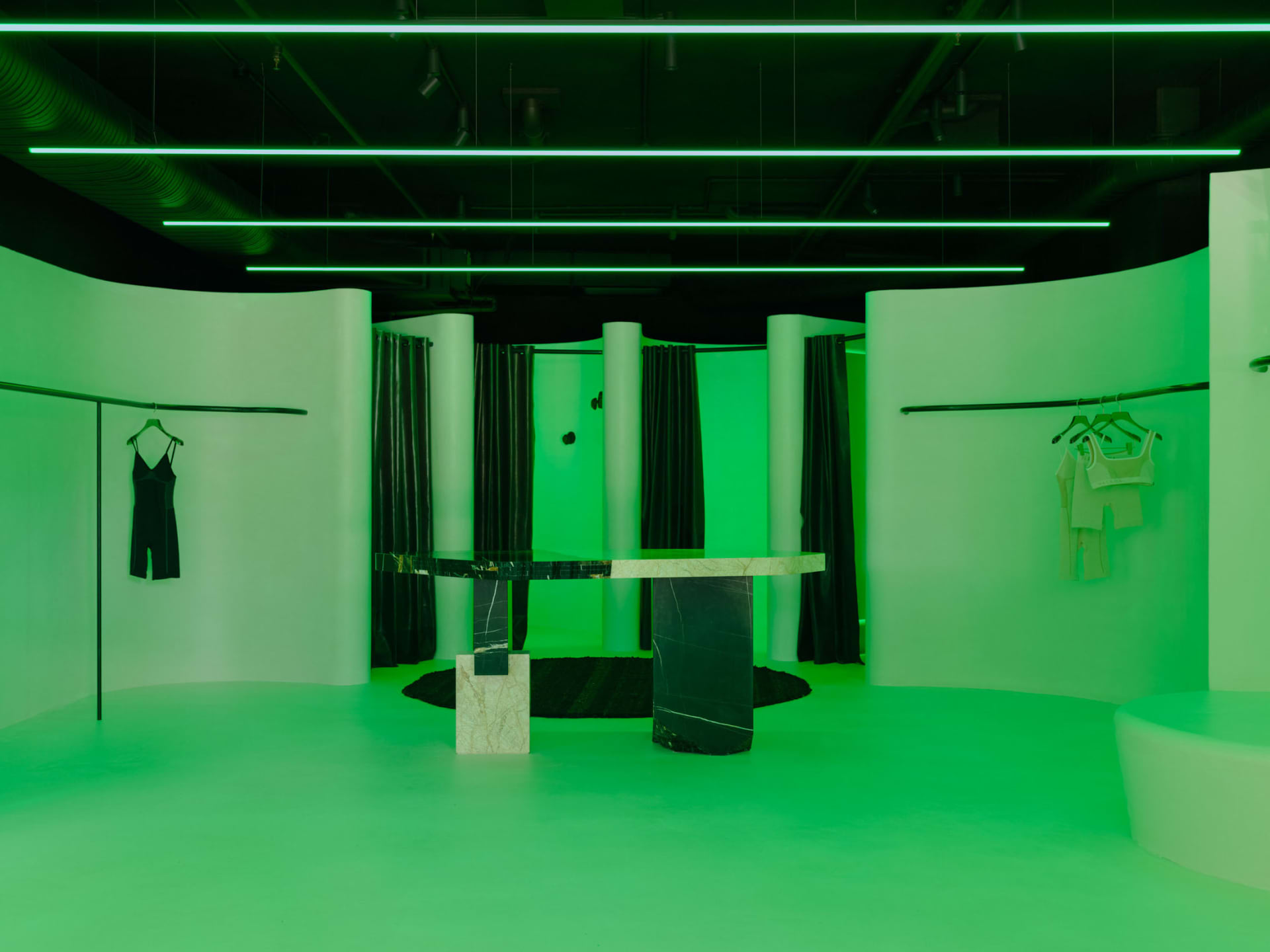 Industrial-style retail showroom with concrete finishes and green lighting