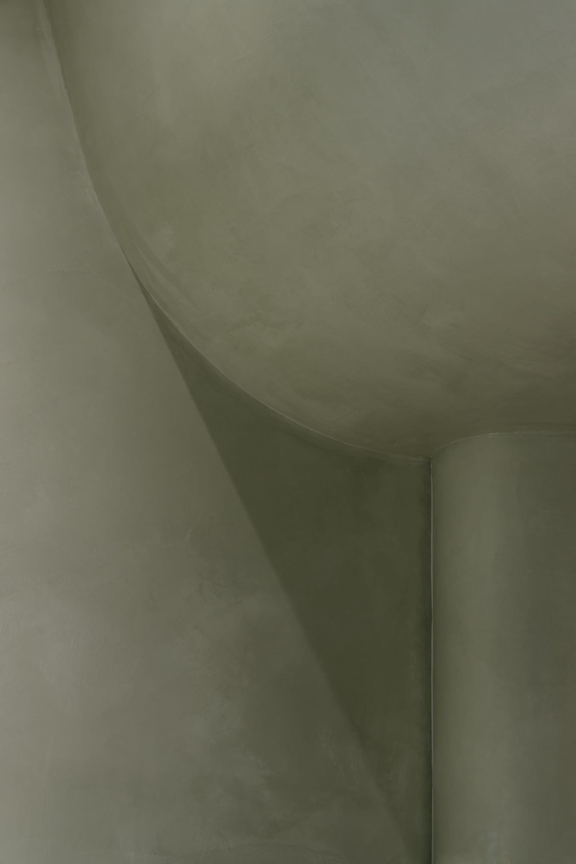 A close-up image of a curved concrete surface with a smooth texture, highlighting architectural details.