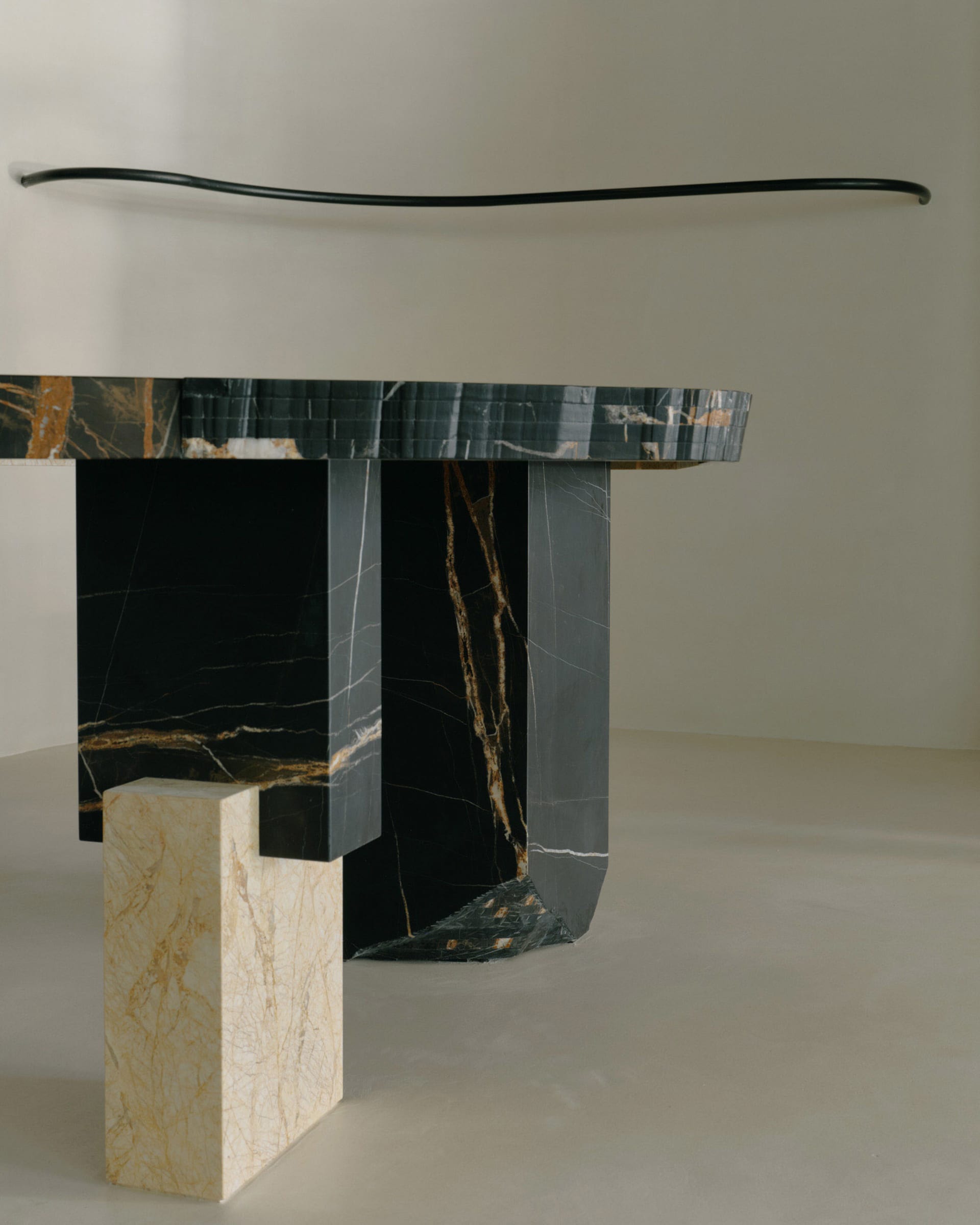 A sleek, modern console table with a curved top made of black marble.