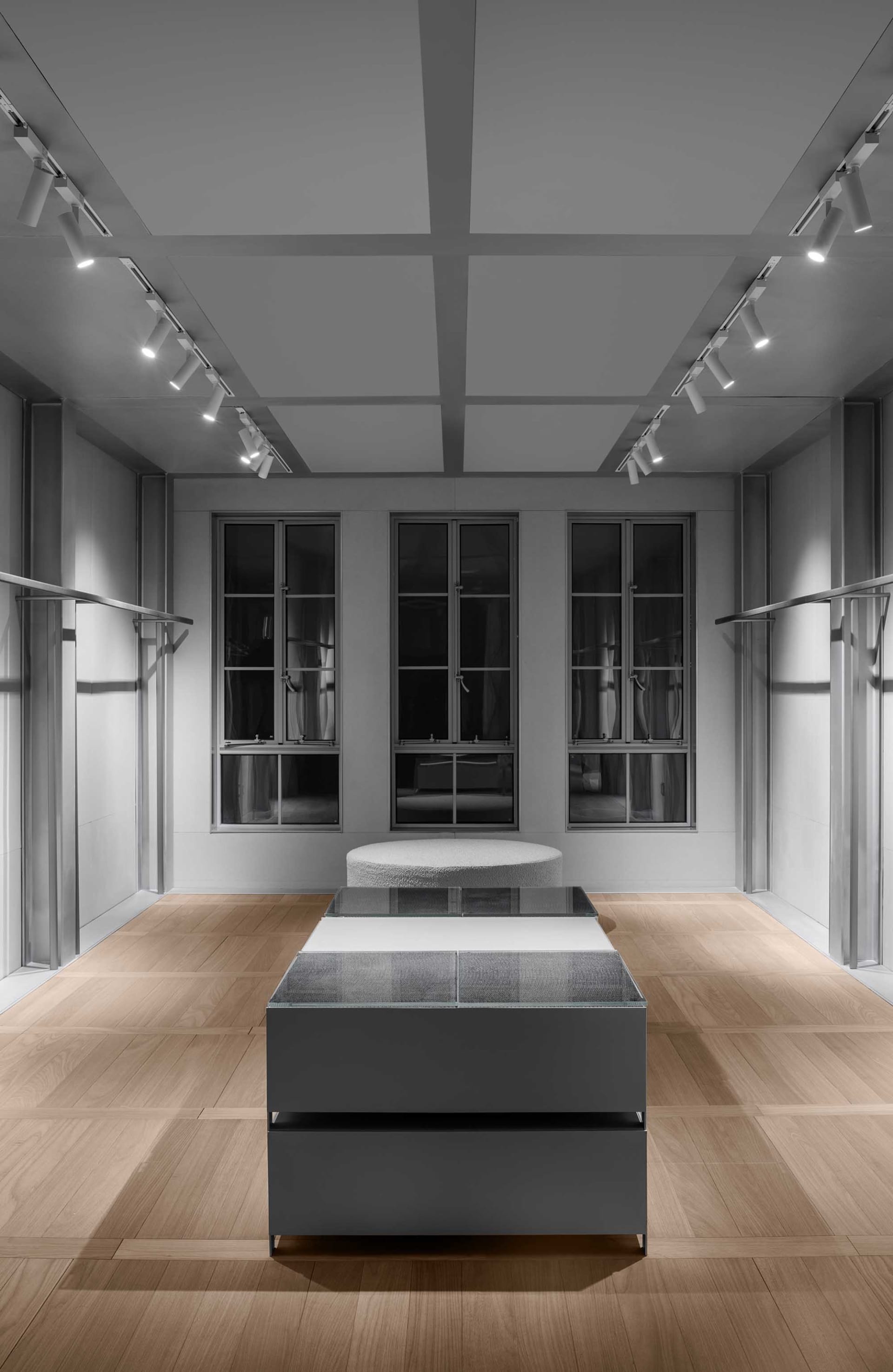 現代展示間陳列白色玻璃家具於木質地板上。