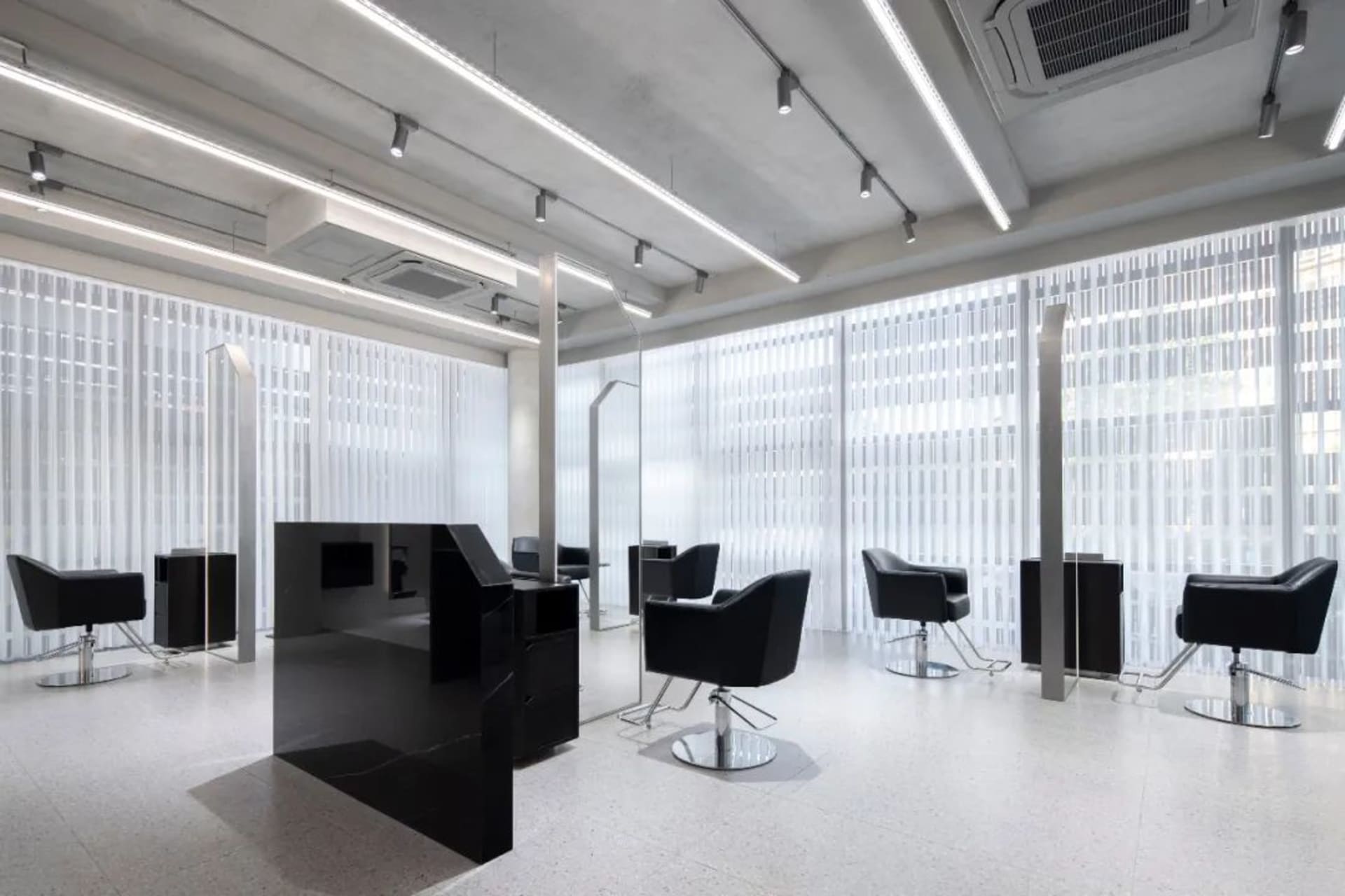 Modern salon interior with black metal chairs and glass dividers