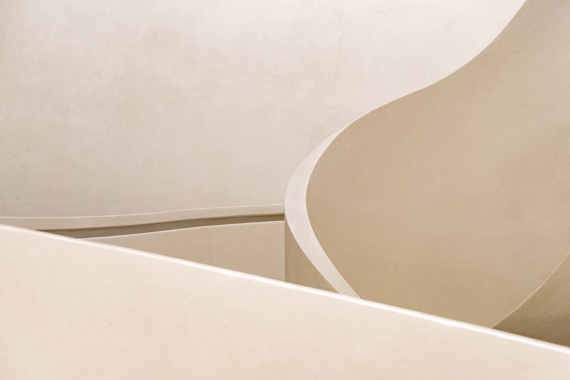 A minimalist, geometric interior design featuring neutral colors and smooth, rounded lines.