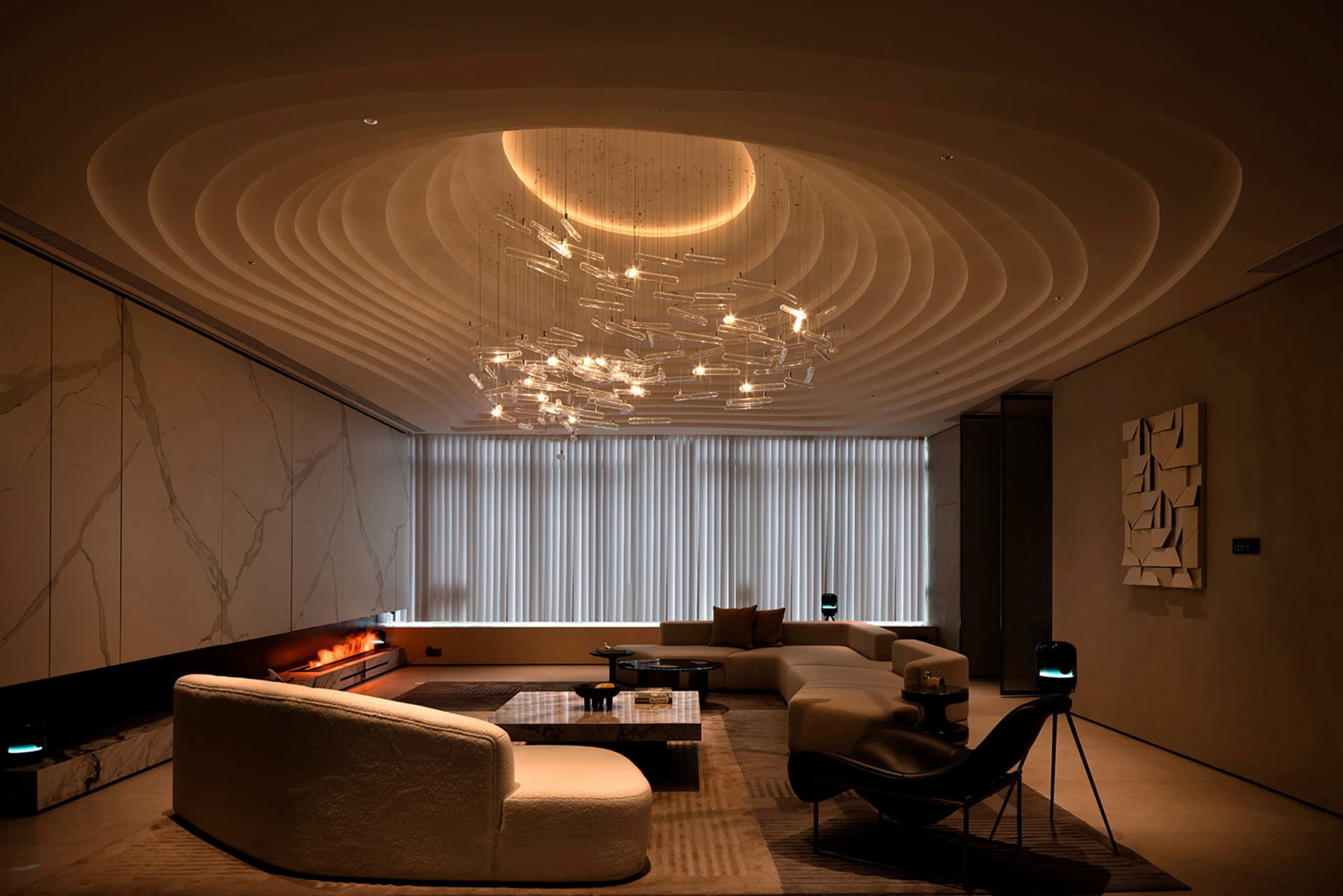 Modern living room with marble walls, glass chandelier, and leather furniture