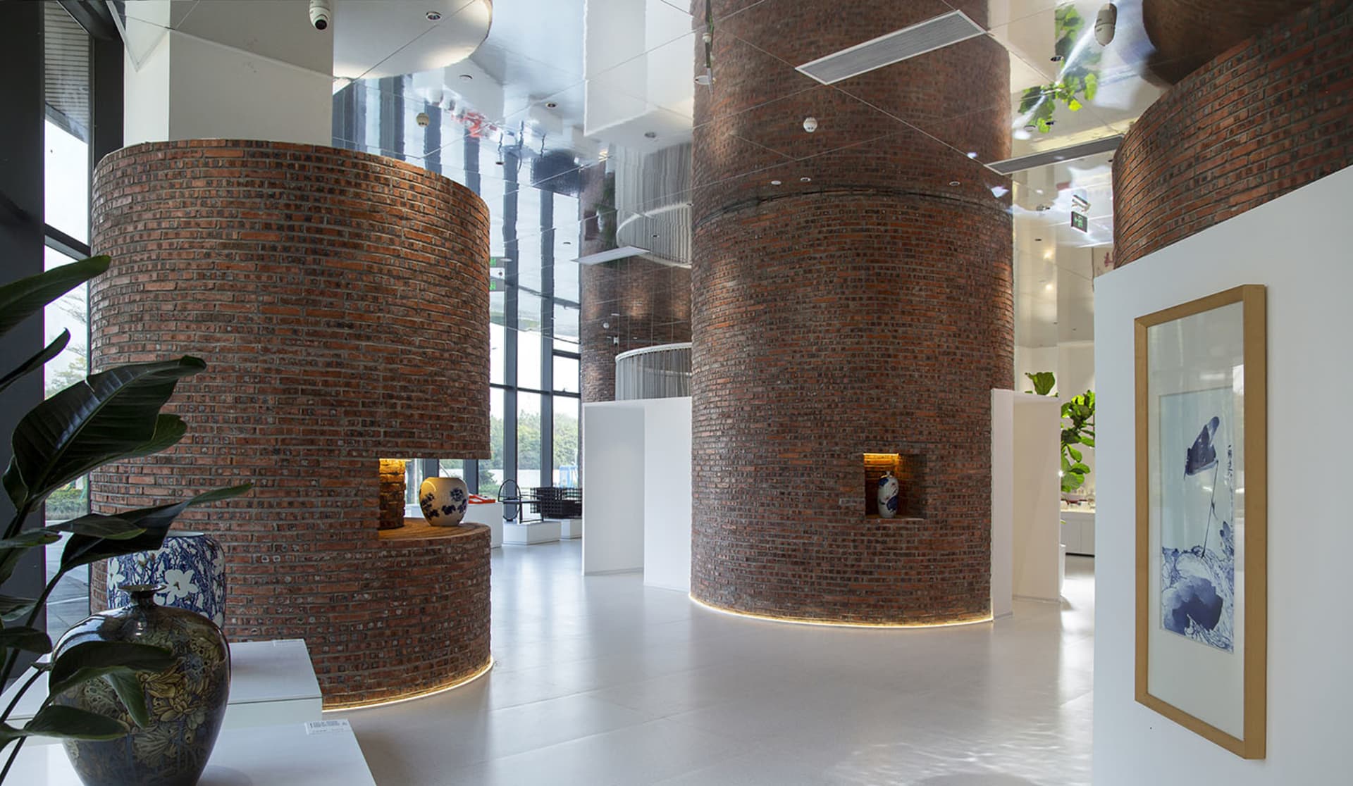 A modern lobby with large brick columns and concrete flooring.