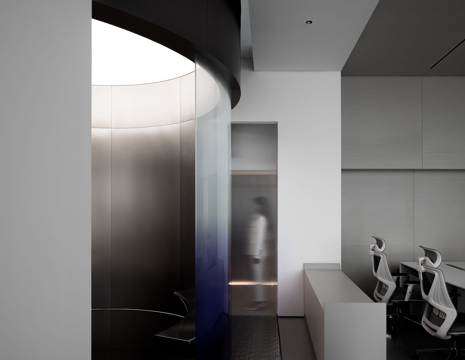 Privacy cubicle with glass and steel walls and floor, providing modern architectural design elements.