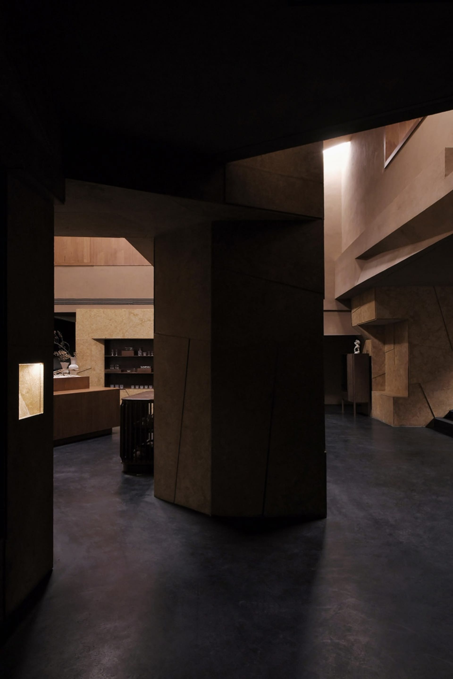 Concrete interior space with geometric shapes and warm lighting.
