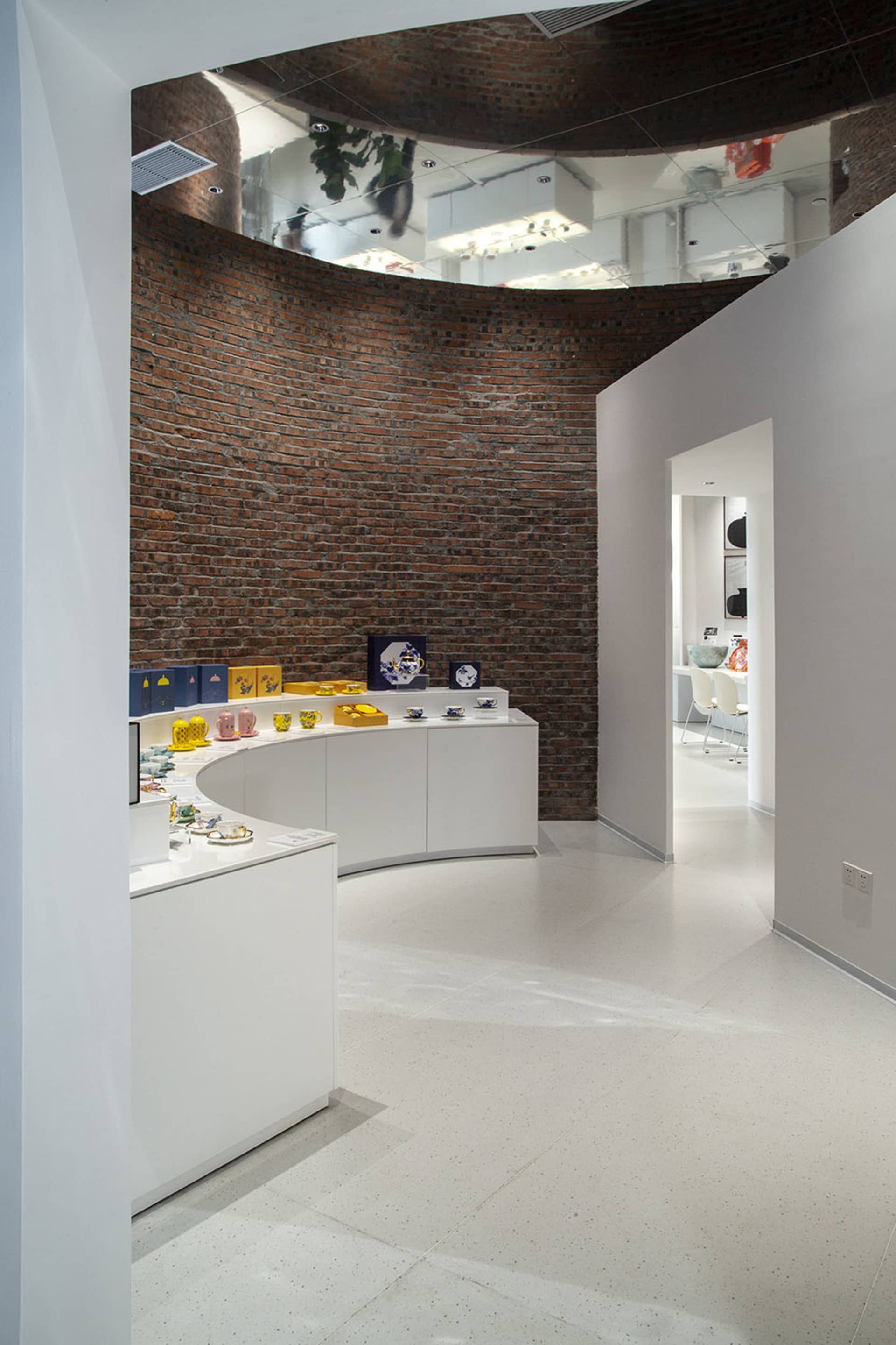 White retail storefront with wooden walls and white furniture on a white floor