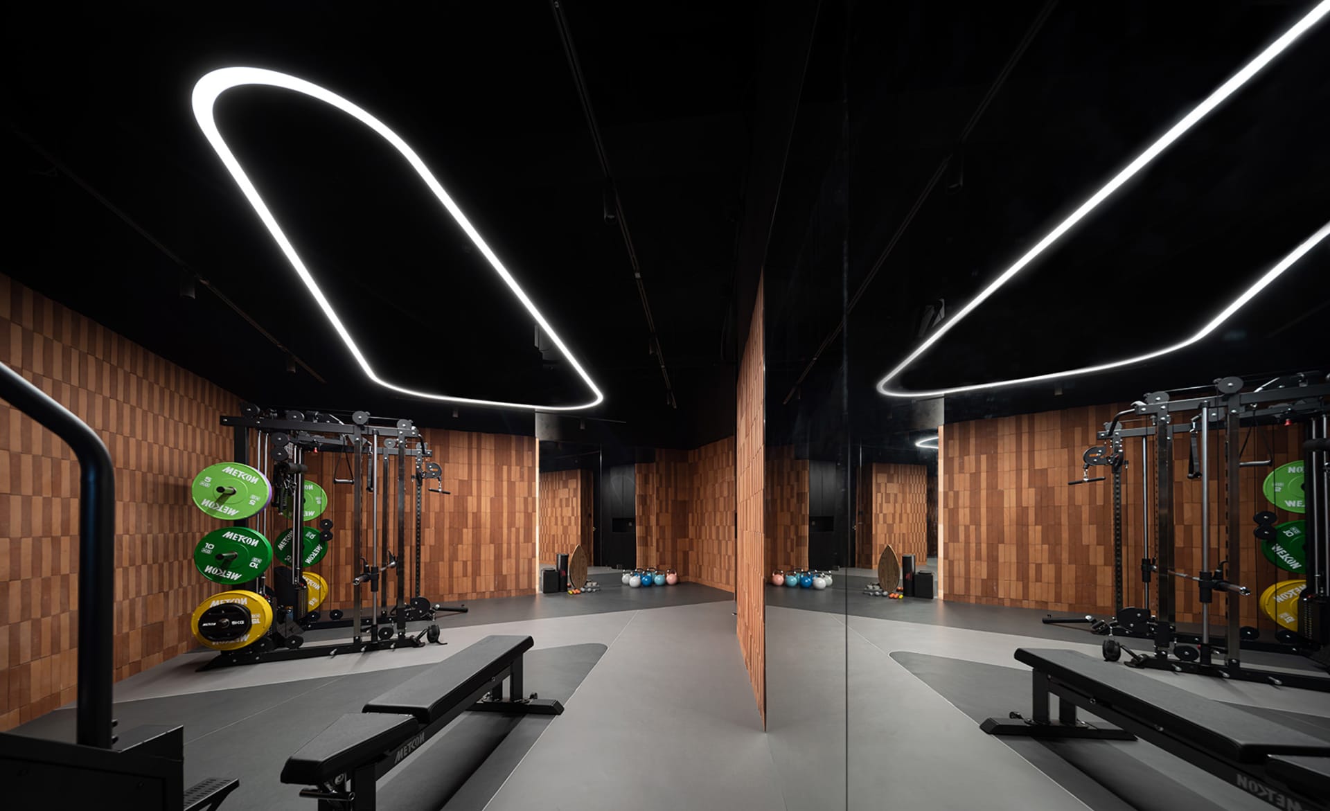 A minimalist fitness center with wooden walls and metal equipment.