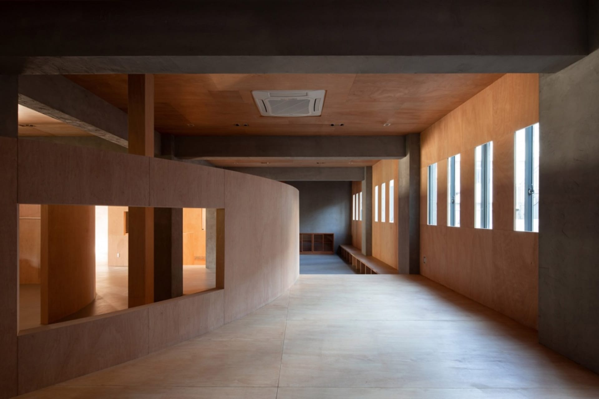 Modern wooden corridor with wood paneled walls and concrete floor