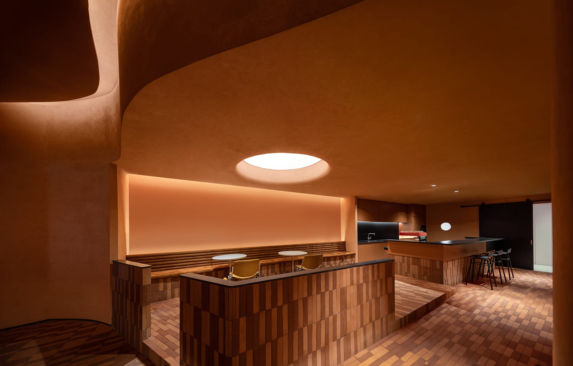 A minimalist restaurant interior with wooden elements and warm lighting.