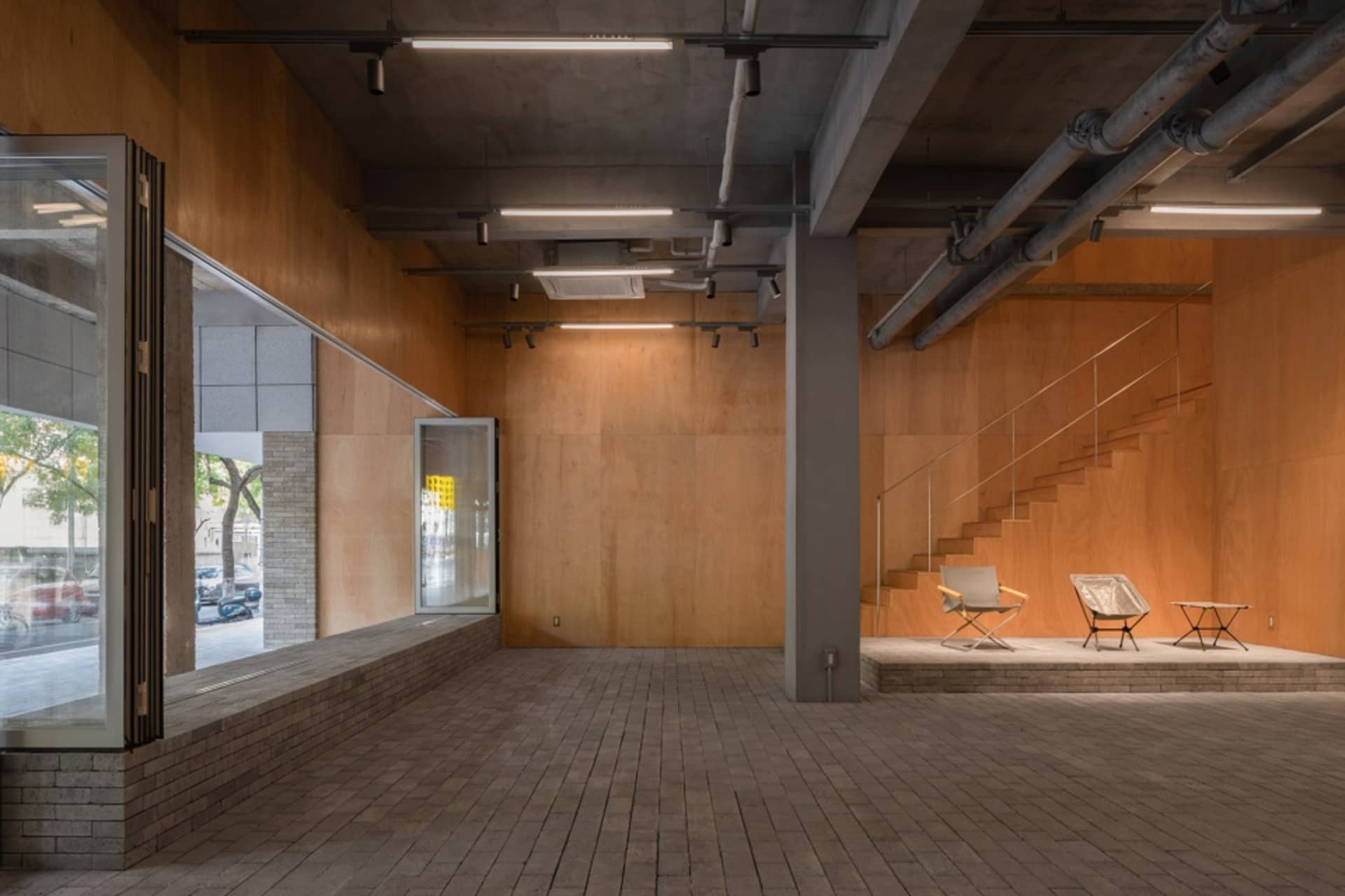 An empty commercial space with wooden walls and floors, featuring a modern and clean design.