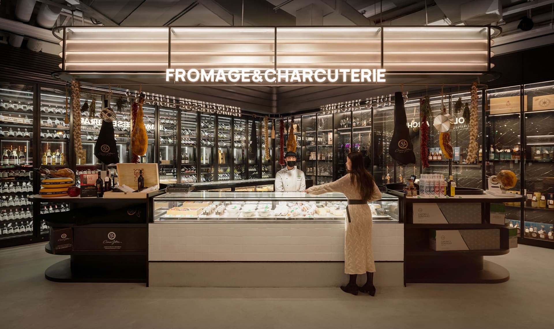 Modern retail storefront with a cheese and charcuterie counter, featuring wooden counters and glass display cases.