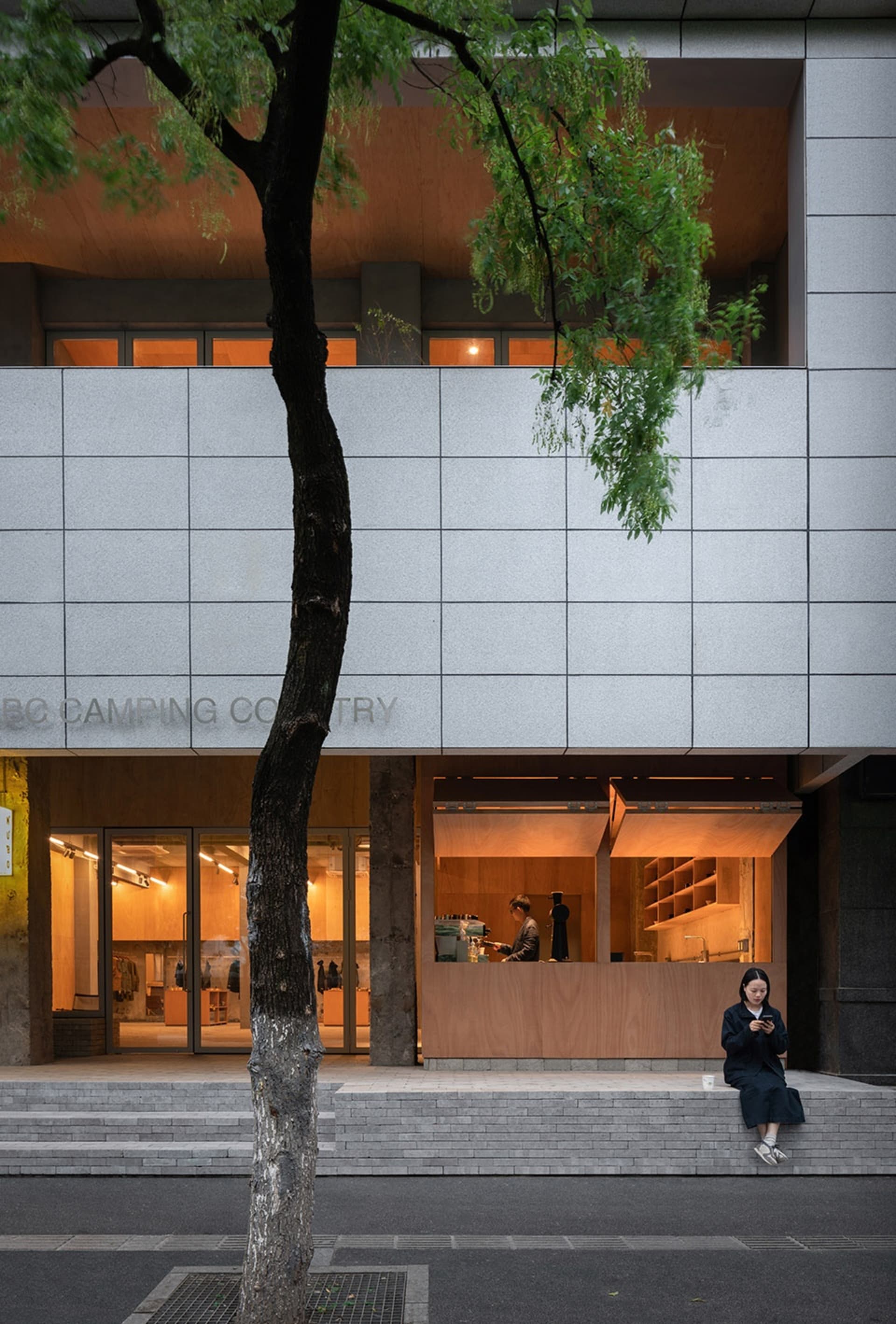 現代零售店面,混凝土外牆搭配溫暖的室內燈光。