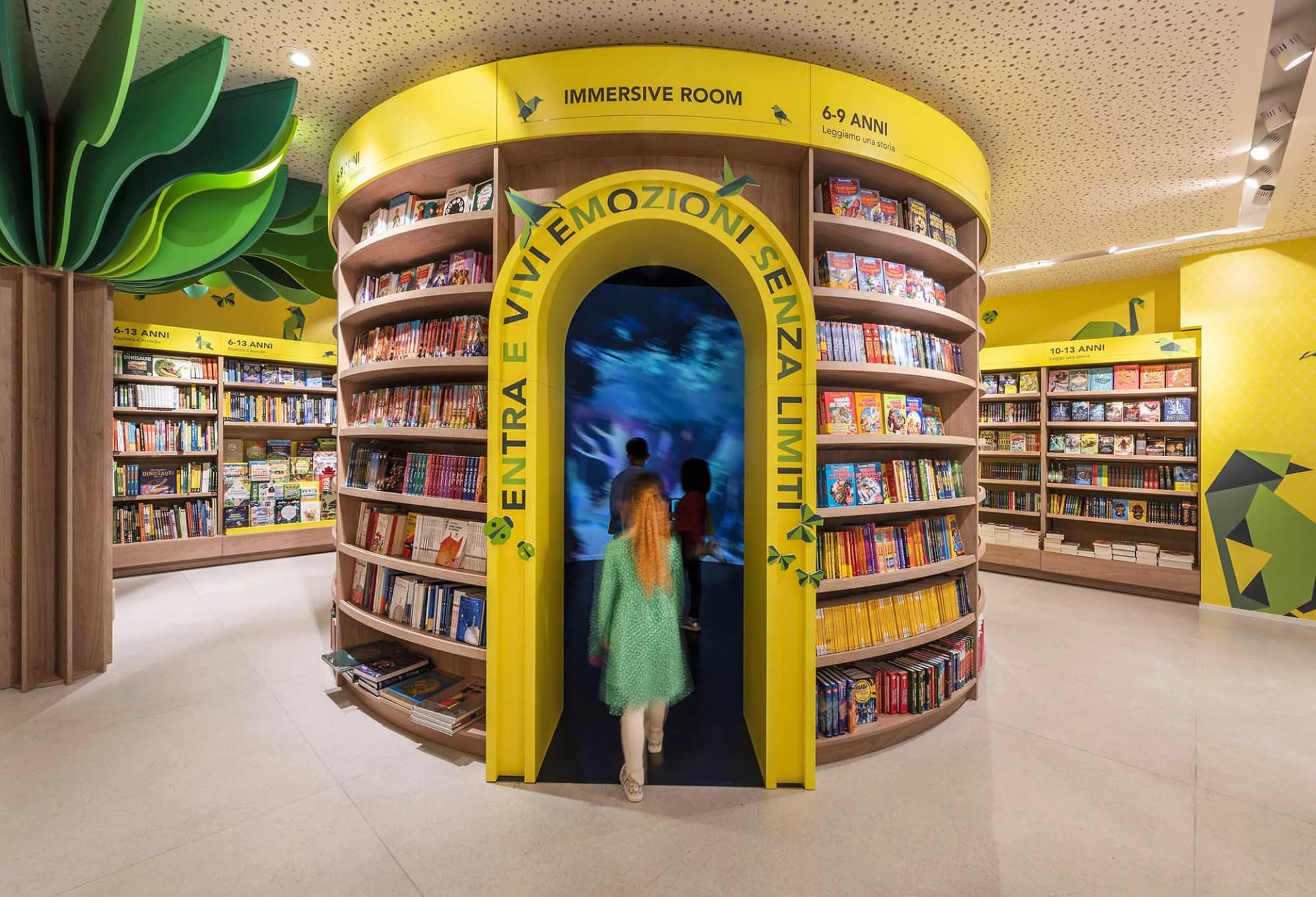 適合6至9歲兒童的圖書館沉浸式空間,設有木質書架陳列書籍,並配有數位螢幕