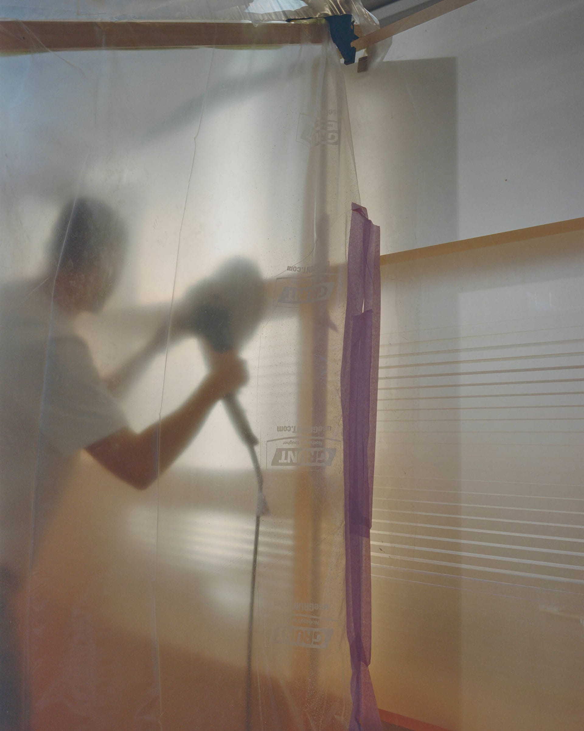 Person sanding plastic wrap in a construction setting