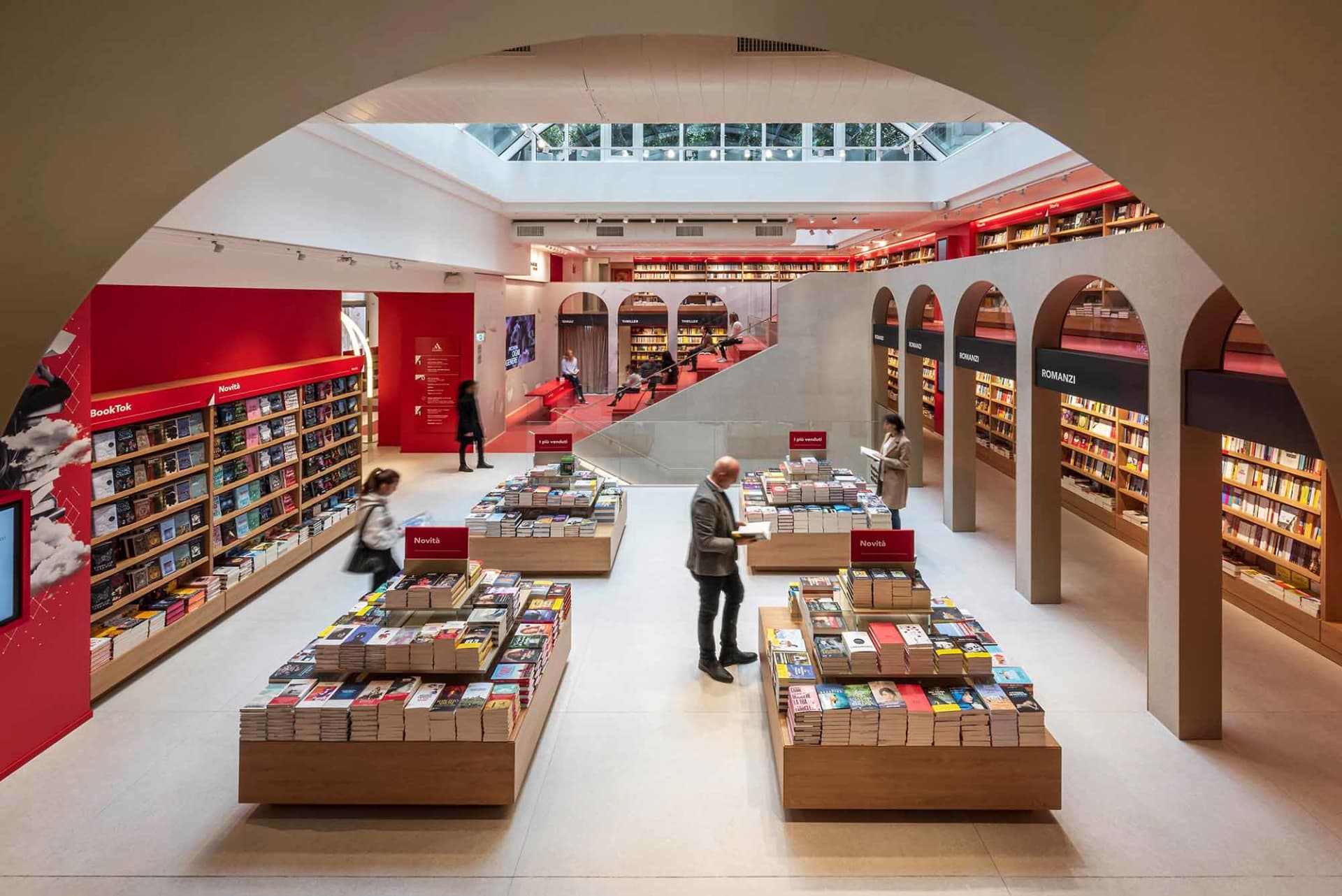 現代書店室內空間,設有混凝土柱、玻璃牆,以及擺滿各式書籍的書架。