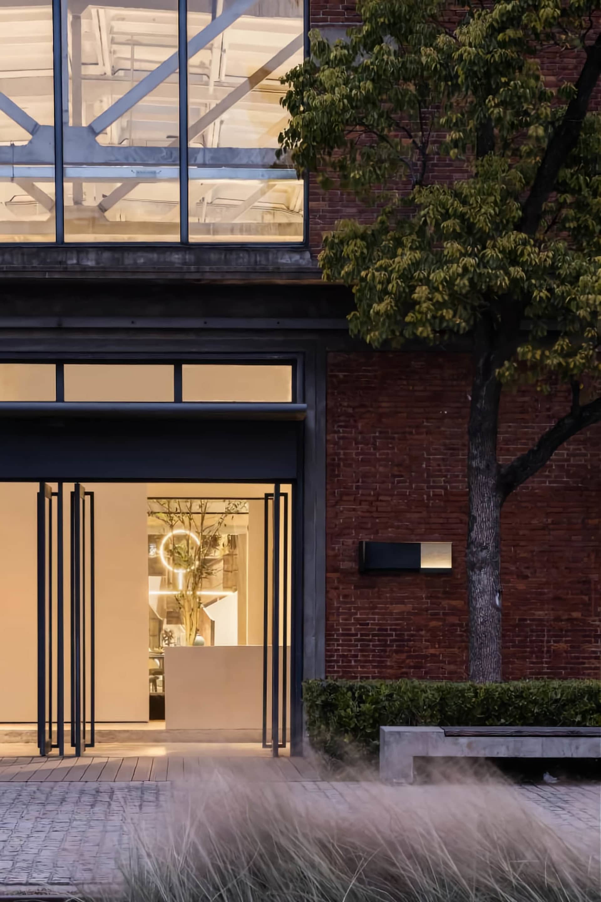 Modern retail storefront with large glass windows, red brick walls, concrete floor and steel structural elements
