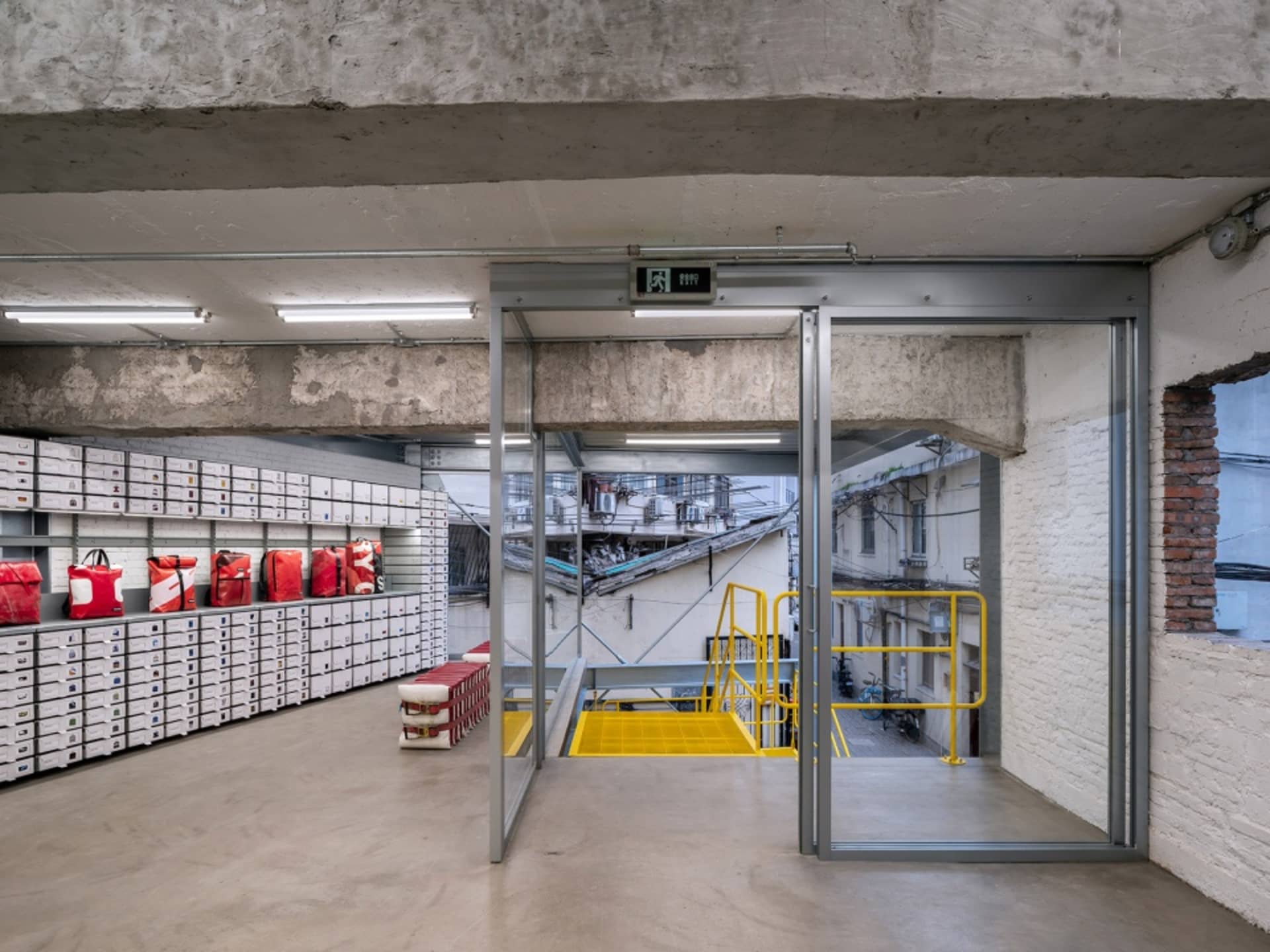 Industrial warehouse interior with metallic materials and large glass doors.