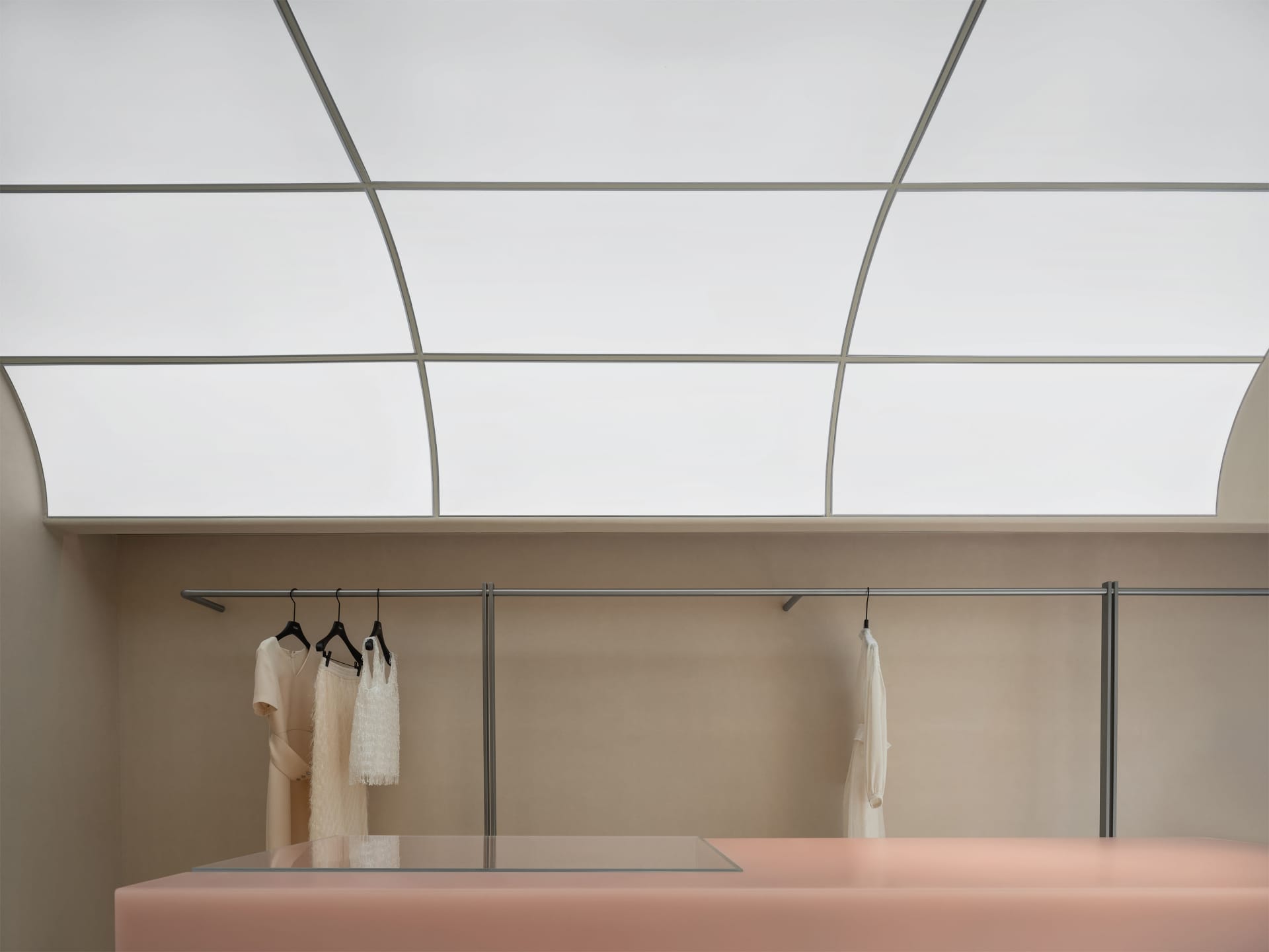 A modern minimalist fashion retail space features concrete and glass materials.