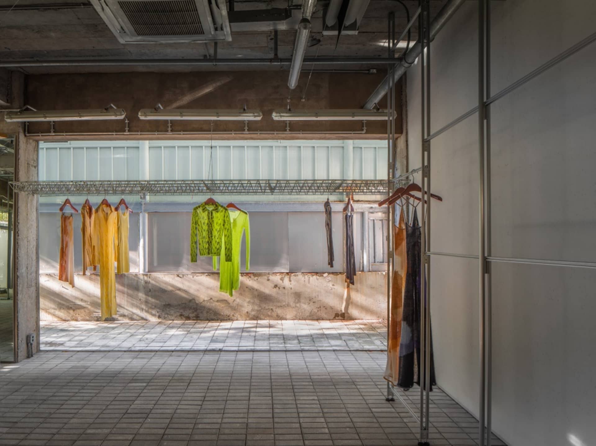 Clothing displayed on hangers in an industrial-style space