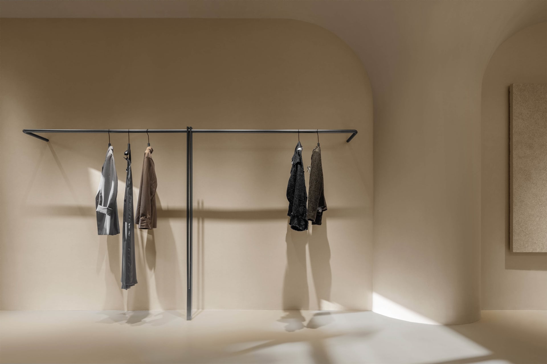 A minimalist clothing display featuring a hanging rack with clothes.
