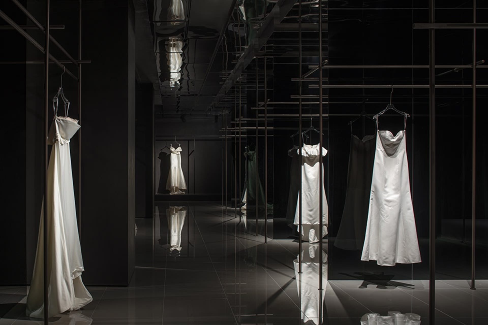 現代極簡服裝展示，搭配俐落金屬衣架與玻璃展示櫃。