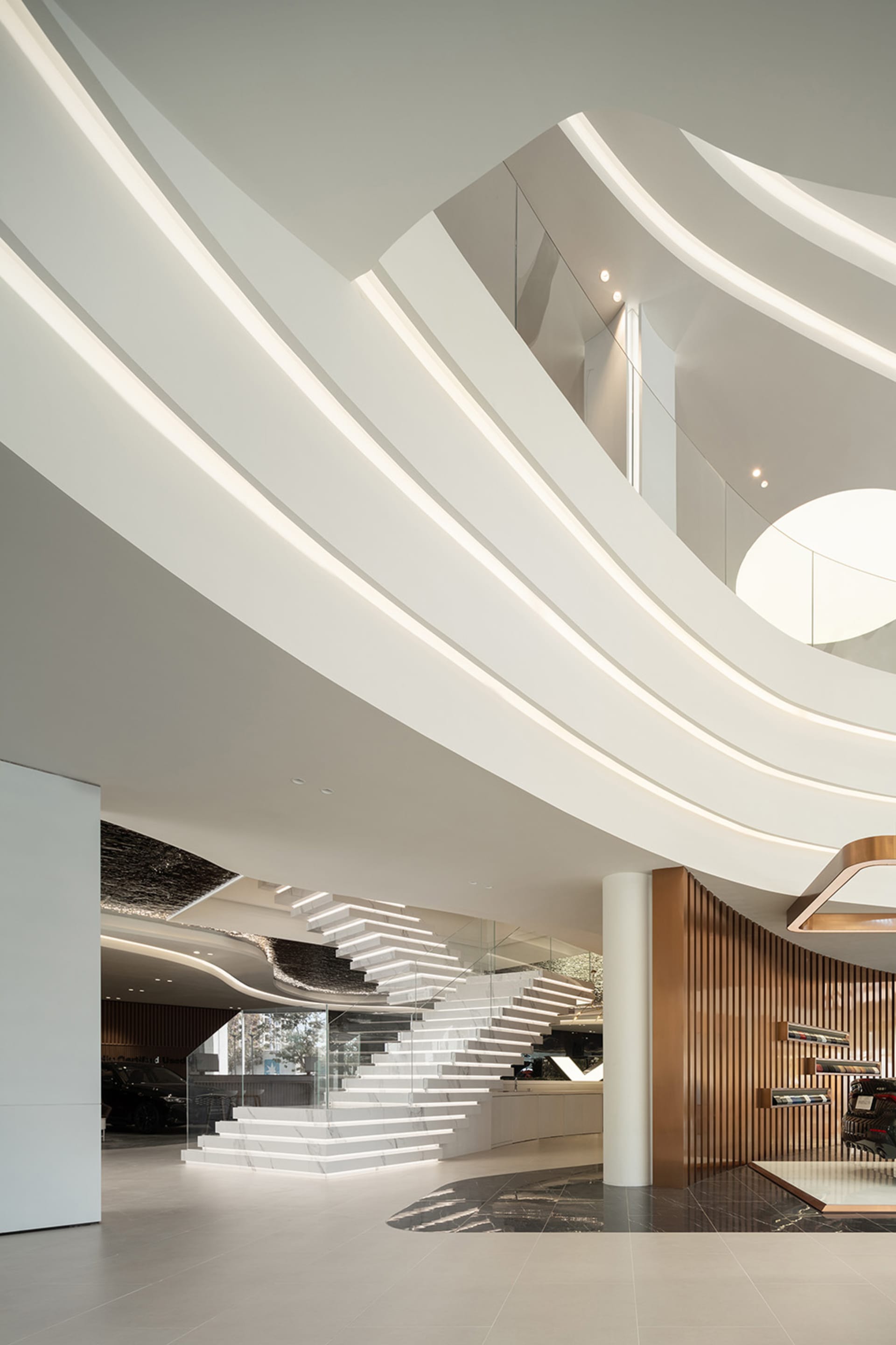 A modern architectural interior design showcasing sleek lines, curved walls, and a prominent staircase.