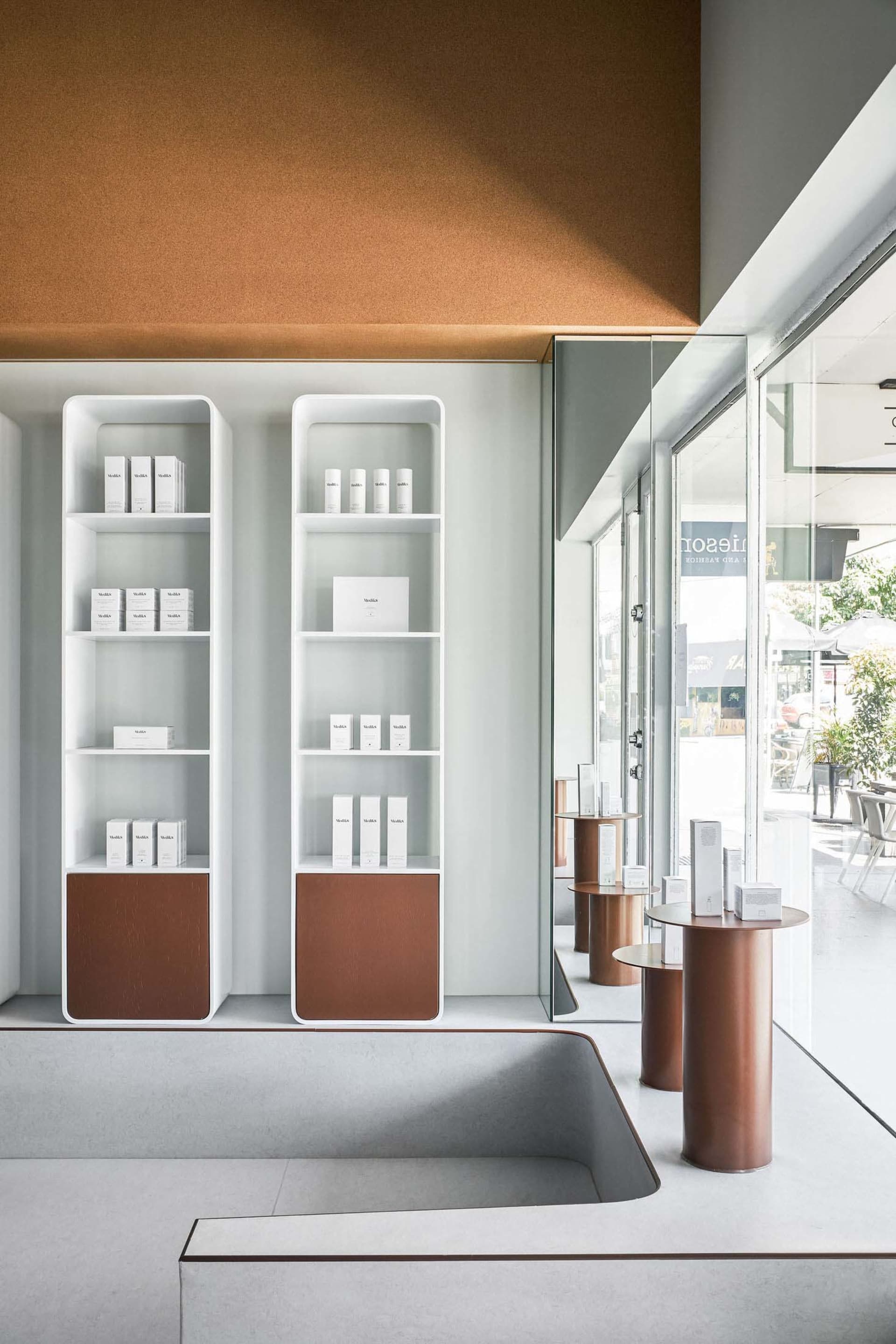 A modern retail store with concrete shelves displaying products.