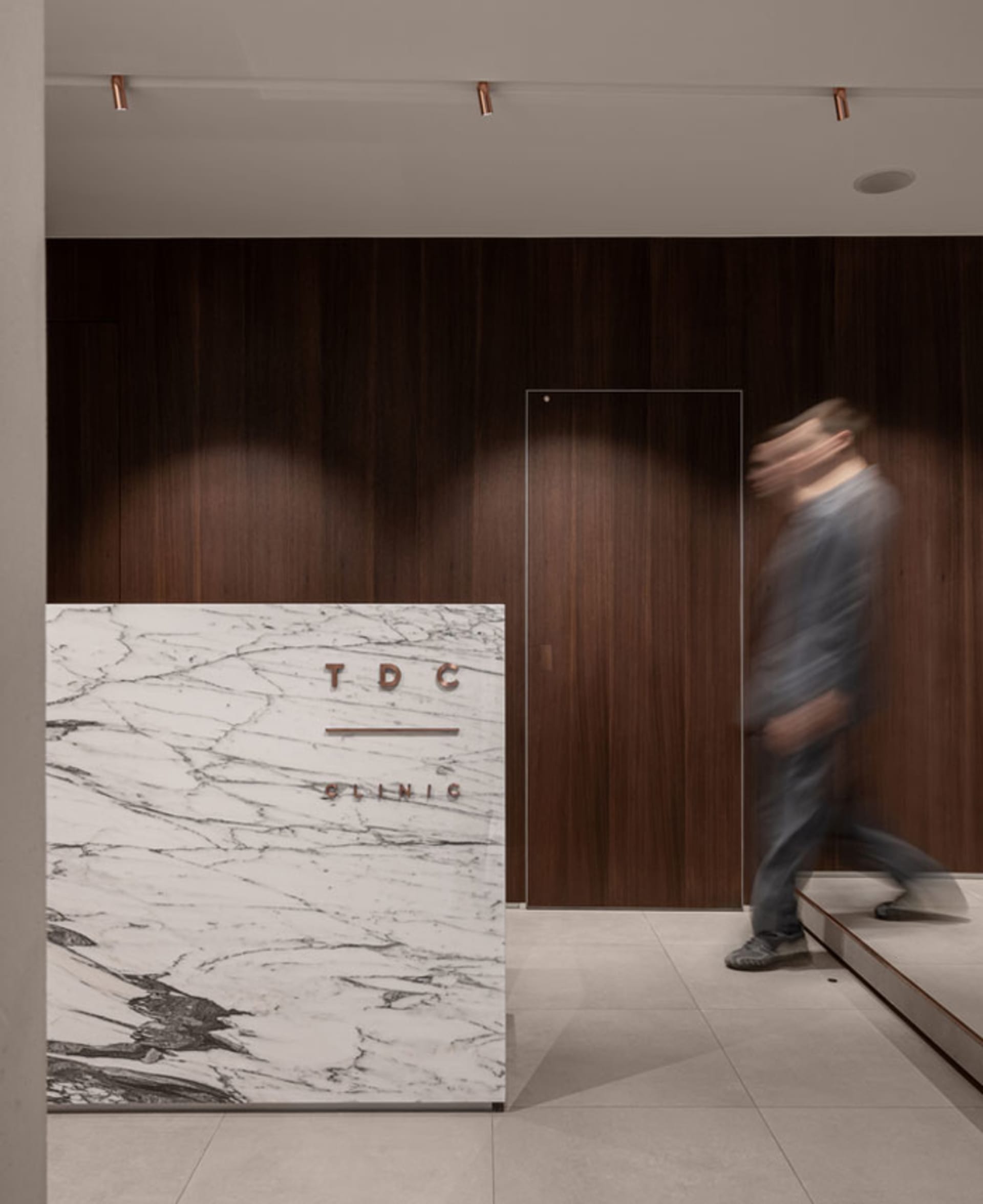 A minimalist, modern office design featuring a marble reception counter.