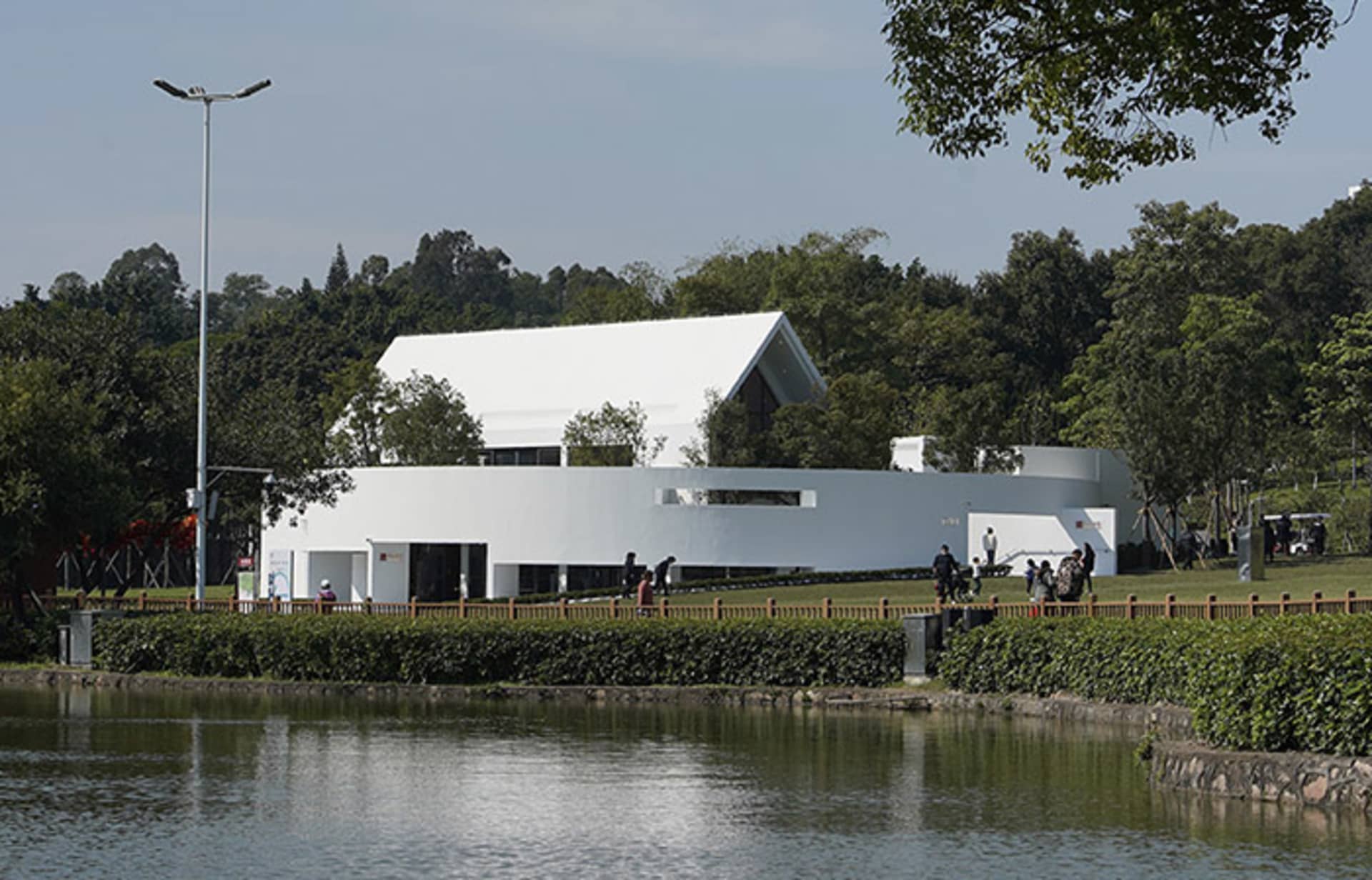 A modern public library with white concrete walls and a curved design.