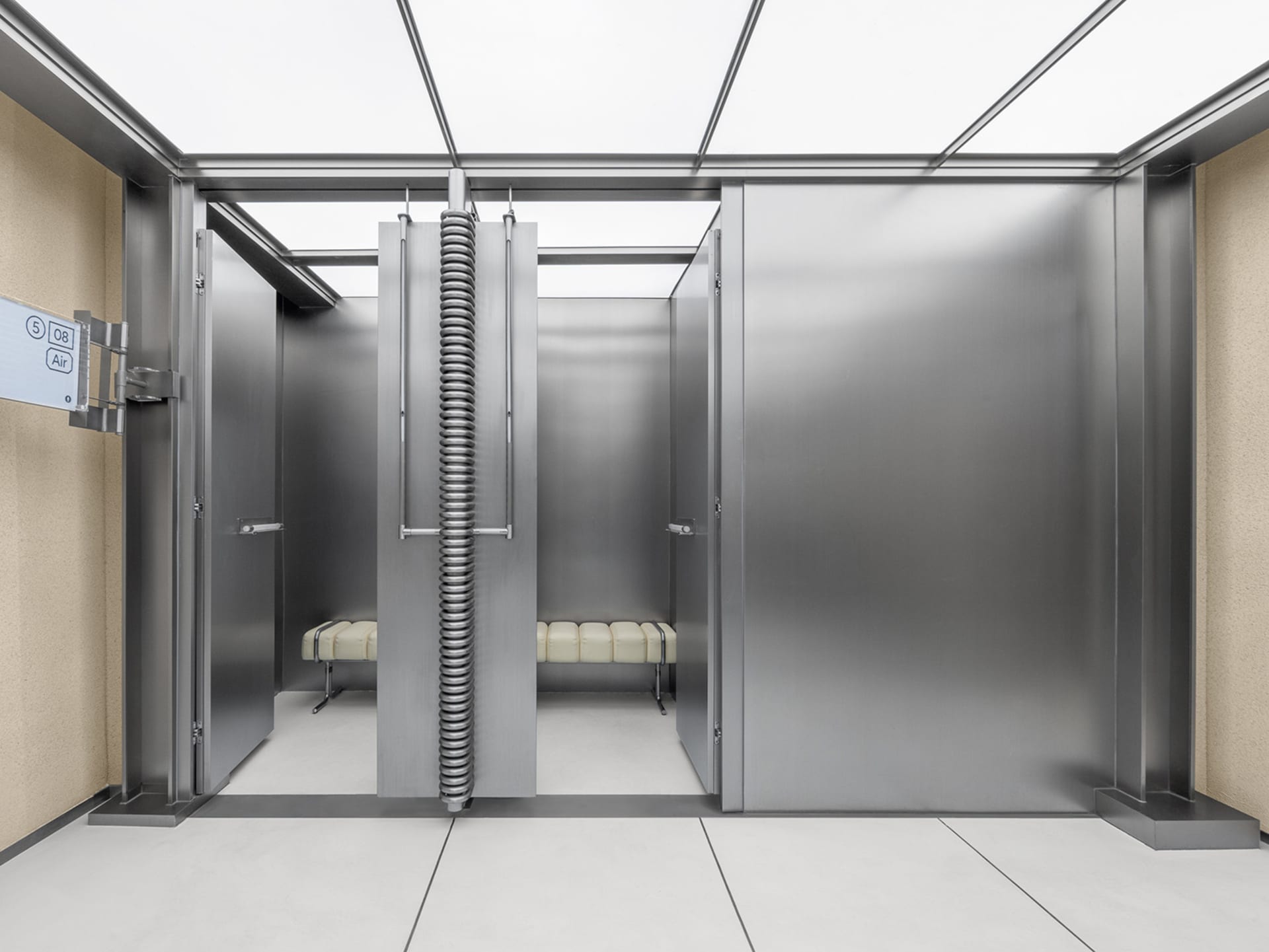 An industrial elevator with metallic walls and modern seating.