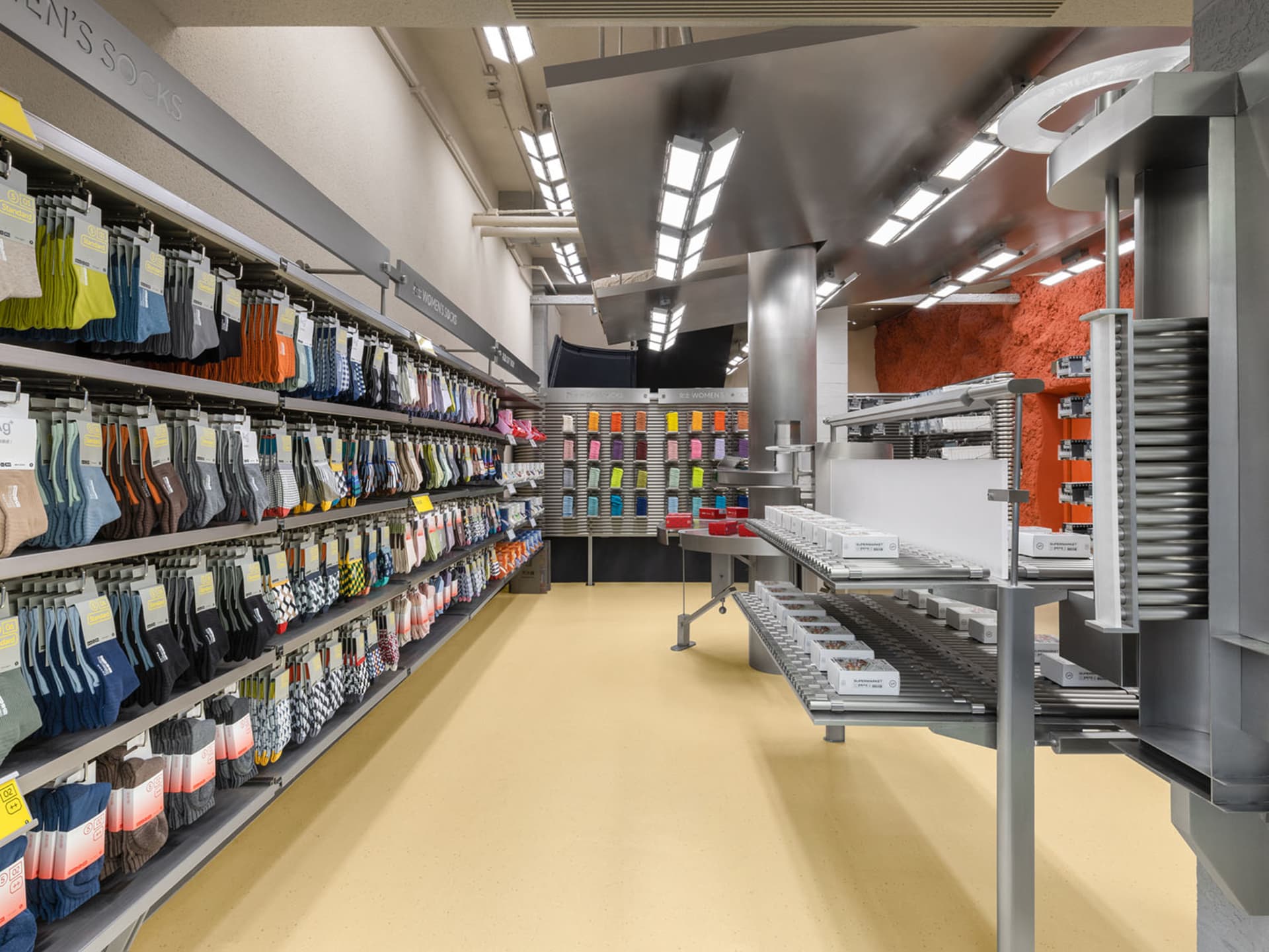 A modern retail store specializing in socks, featuring metal shelves, concrete flooring, and plastic packaging.