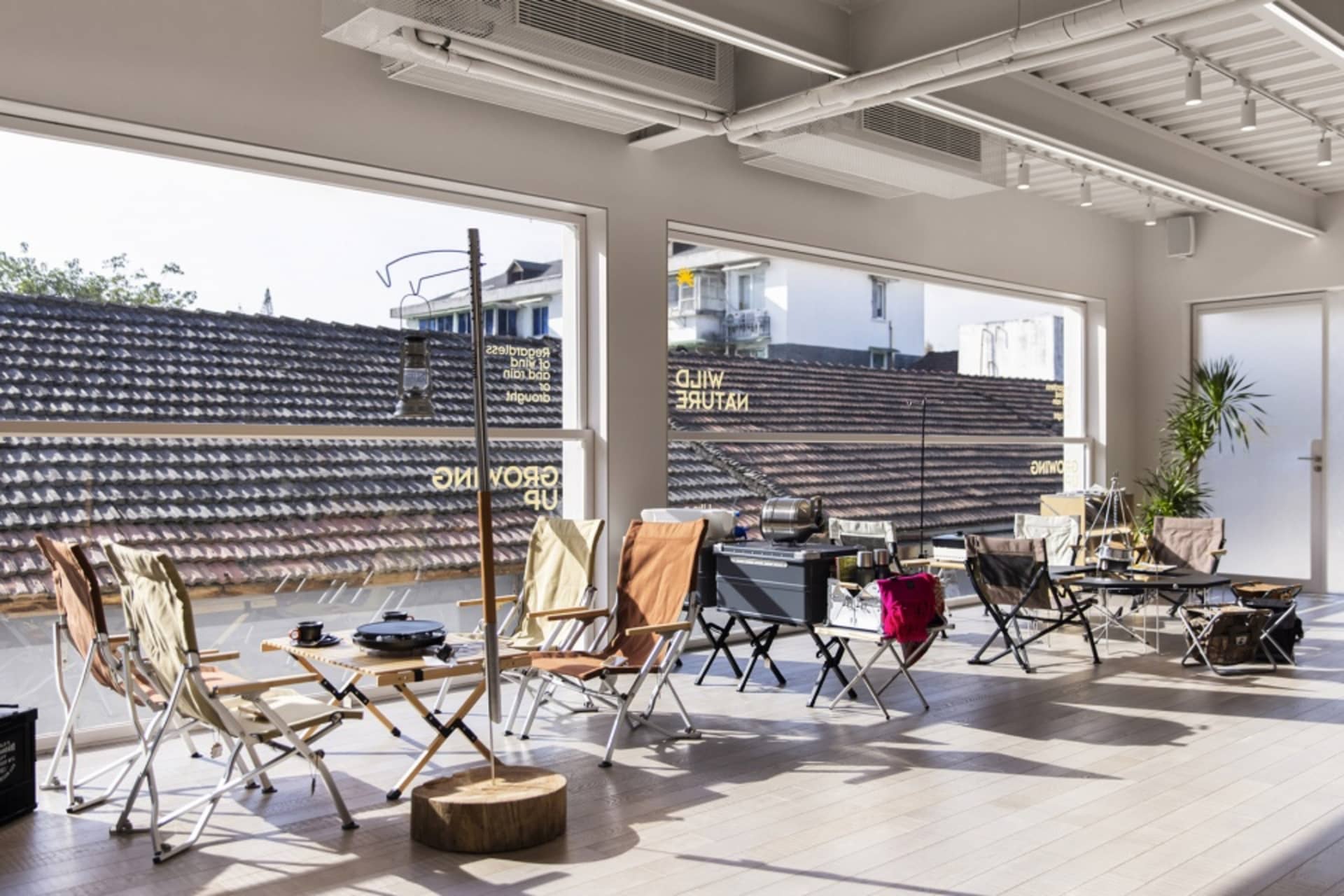 Modern, foldable chairs arranged on a wooden platform with outdoor elements in the background.