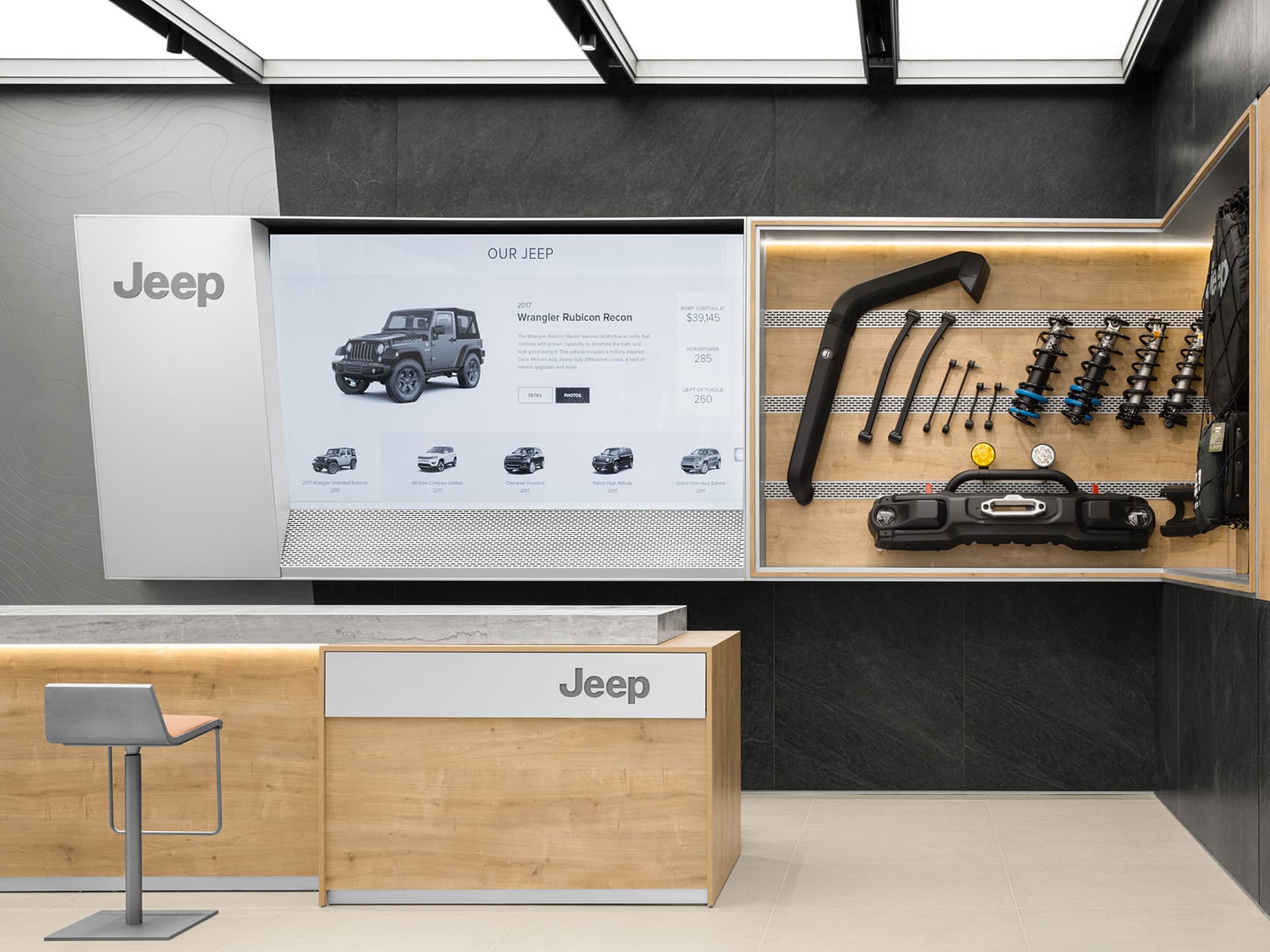 Industrial-style automotive showroom displaying various Jeep vehicles and accessories.